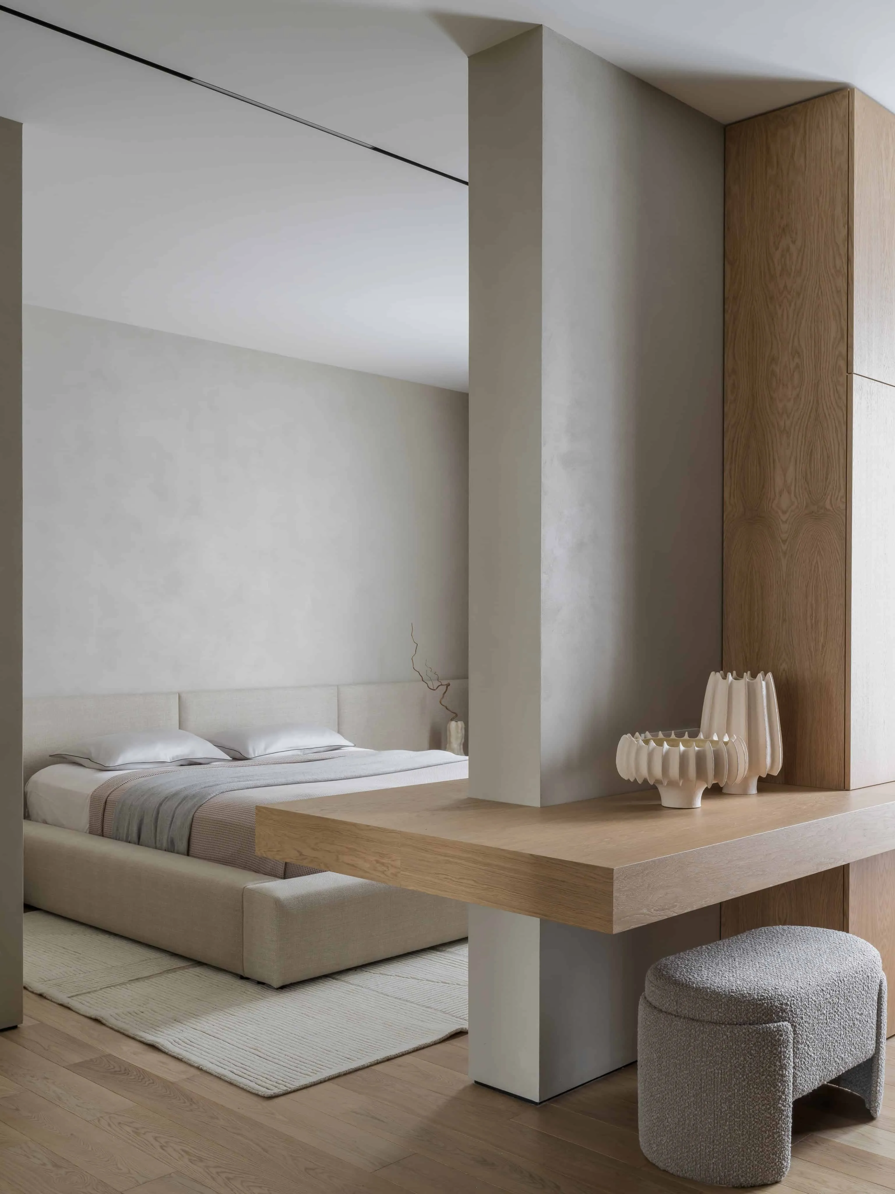 极简卧室设计，内置胡桃木洗手台与柔和中性色调。