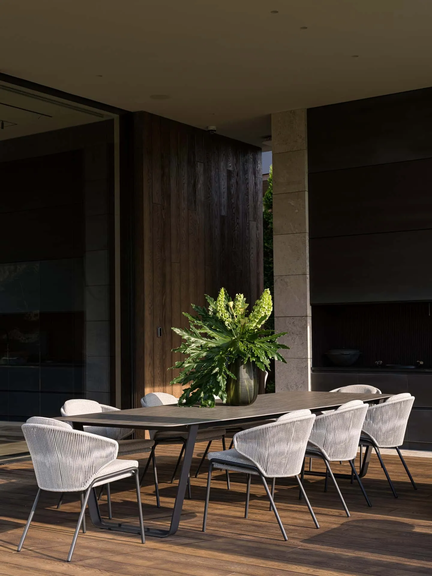 户外用餐区配有现代椅子与花艺。