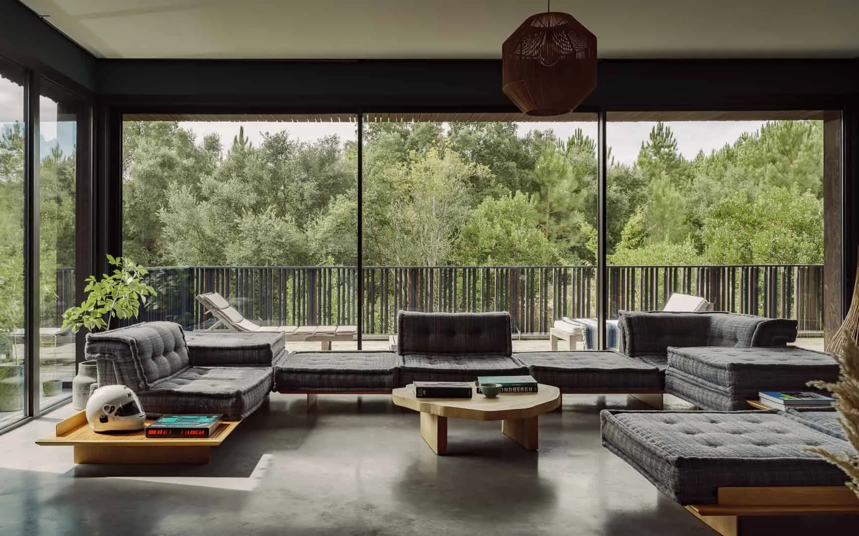 面向森林的现代客厅，配有落地窗。