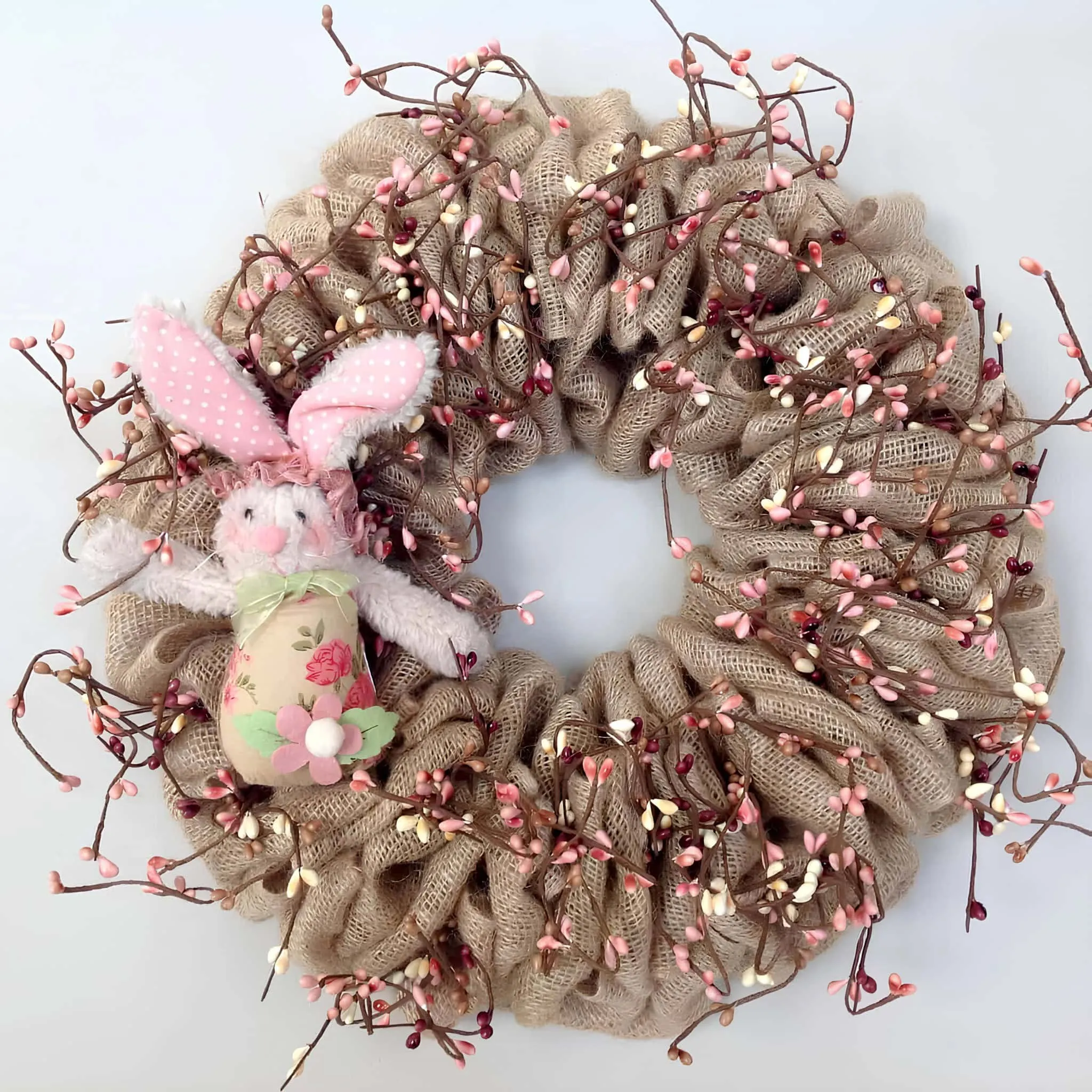 乡村复活节门饰，配有粉红浆果、粗麻雏菊和织物兔子