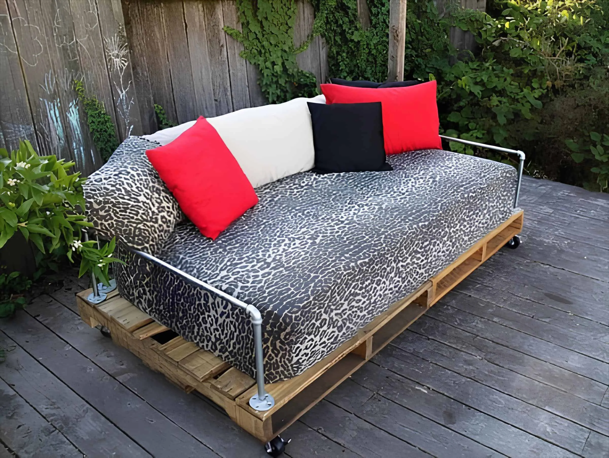 带豹纹图案的托盘午睡床，配有红色、黑色和白色靠垫在轮子上