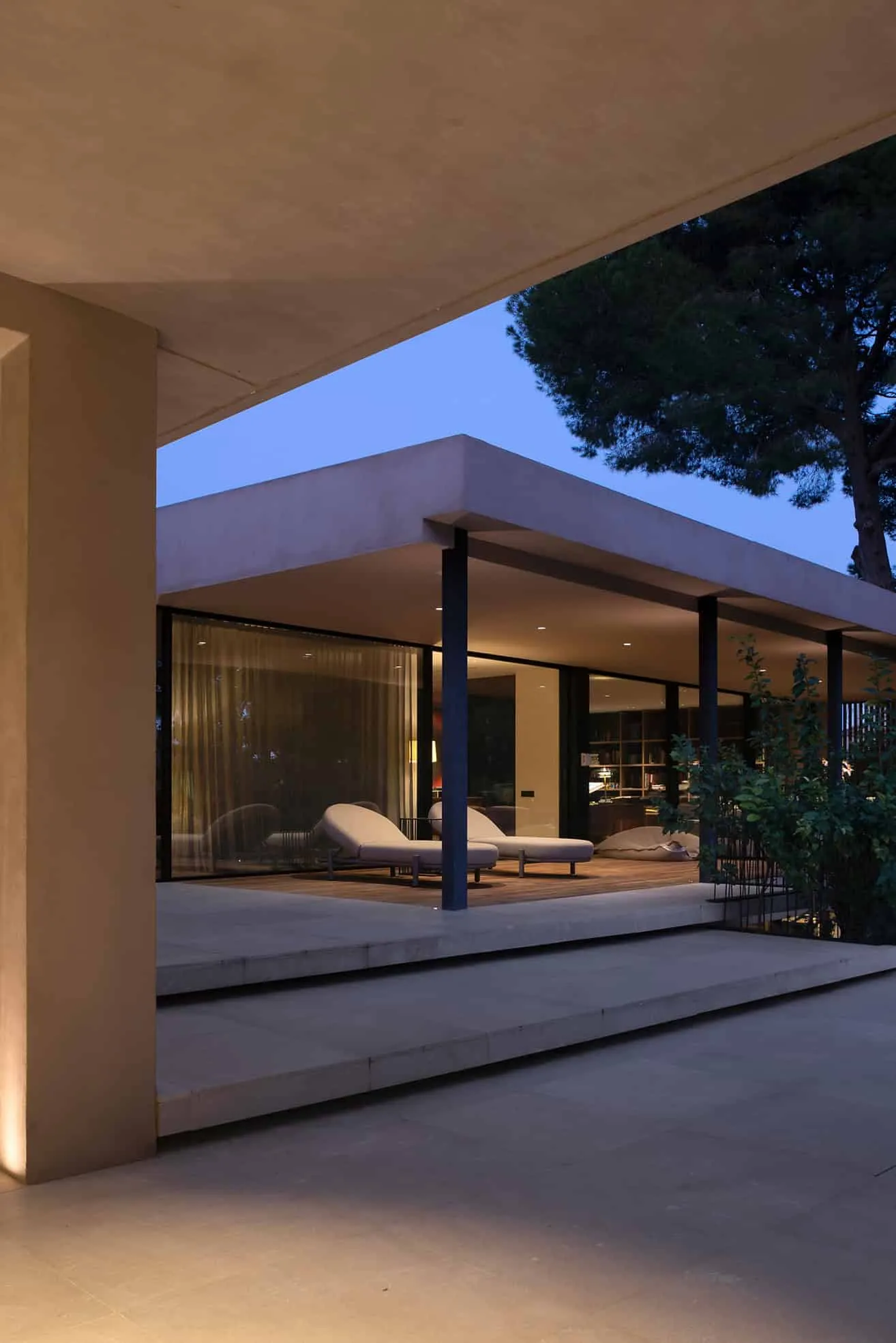 配有极简扶手椅和玻璃窗的傍晚露台。