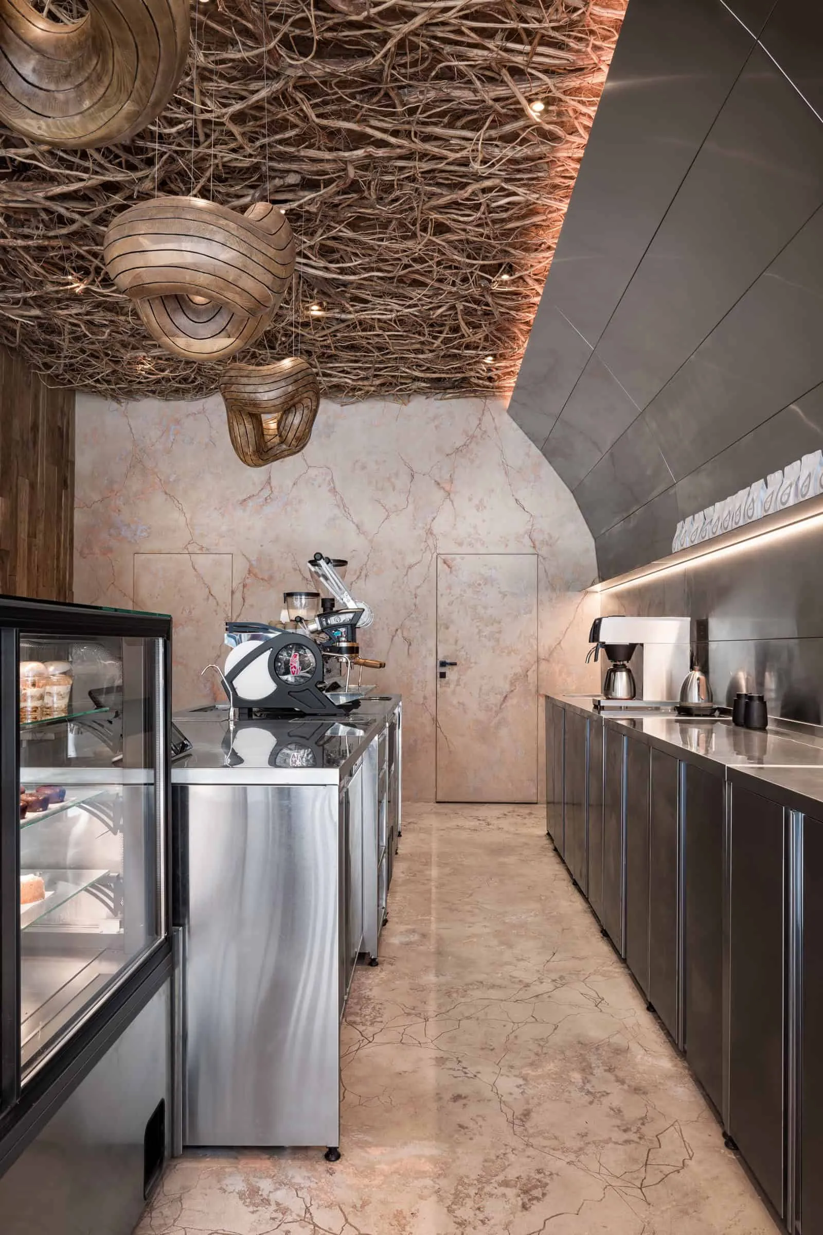 展示咖啡机和不锈钢储物柜的吧台背面视角