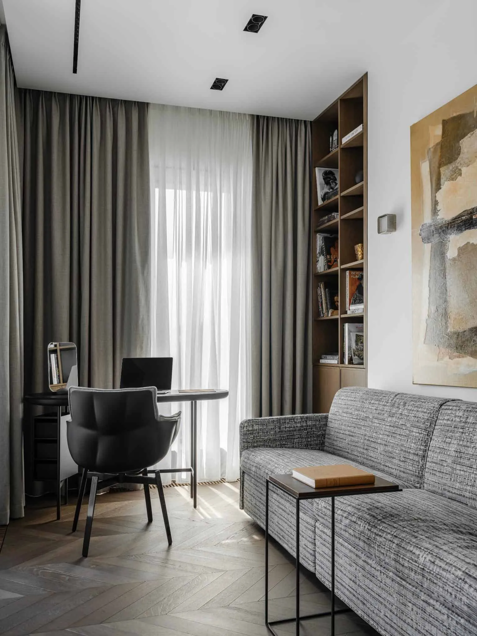 Study with gray curtains and bookshelf.