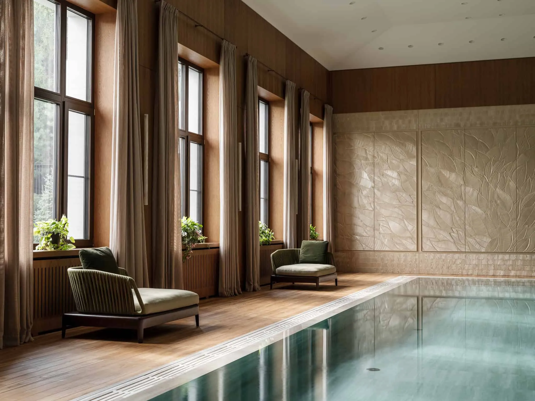 Крісла біля басейну, насолоджуючись природнім світлом від високих вікон.