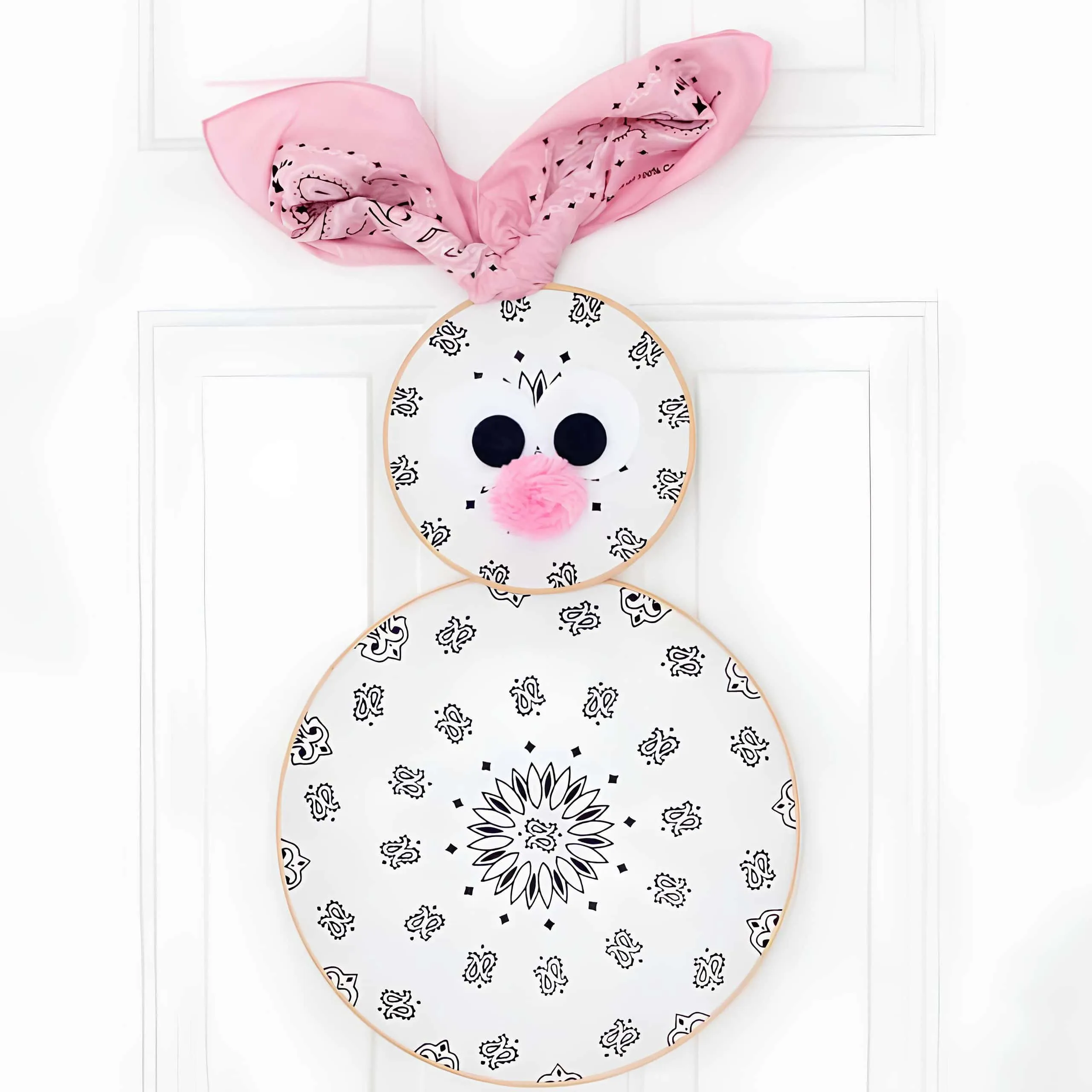 望远镜兔子门饰，由望远镜布料制成，配有粉色小鼻、大眼睛和柔软的粉红耳朵，在白色门上。