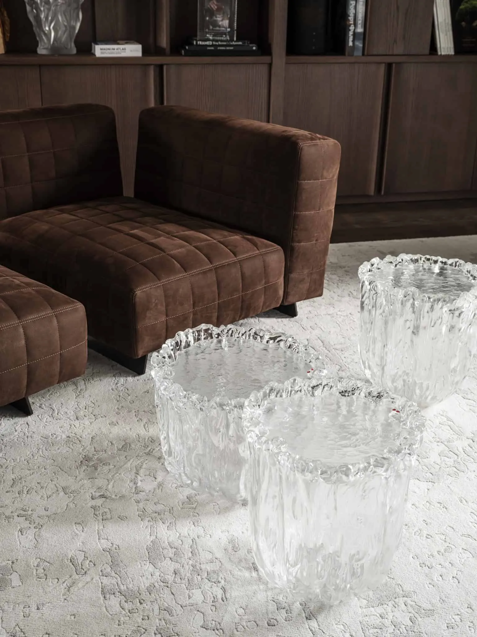 Прозорі скляні табуретки з органічною формою на світлому текстурованому килимі.