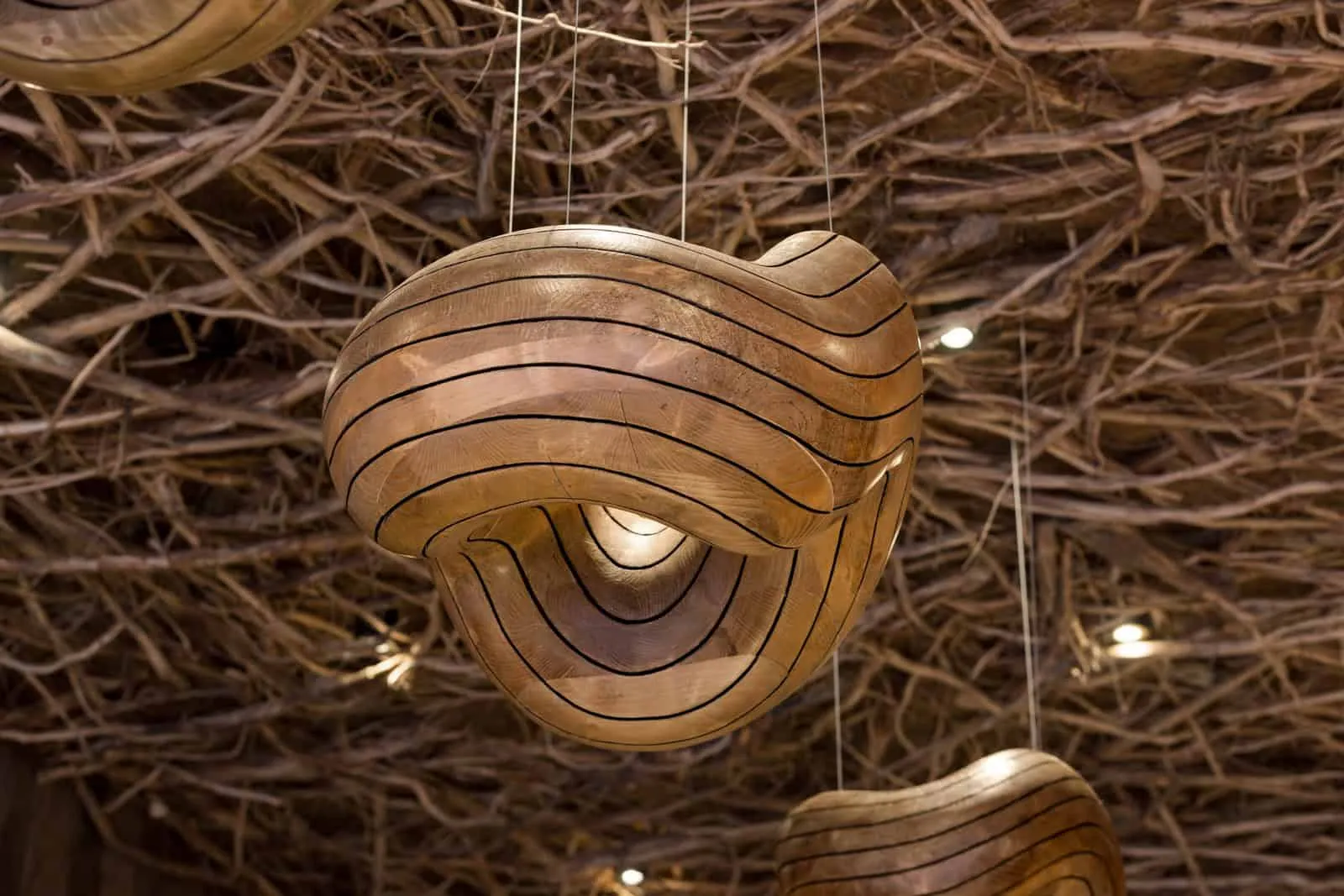 温馨咖啡馆天花板中的弯曲木质吊灯