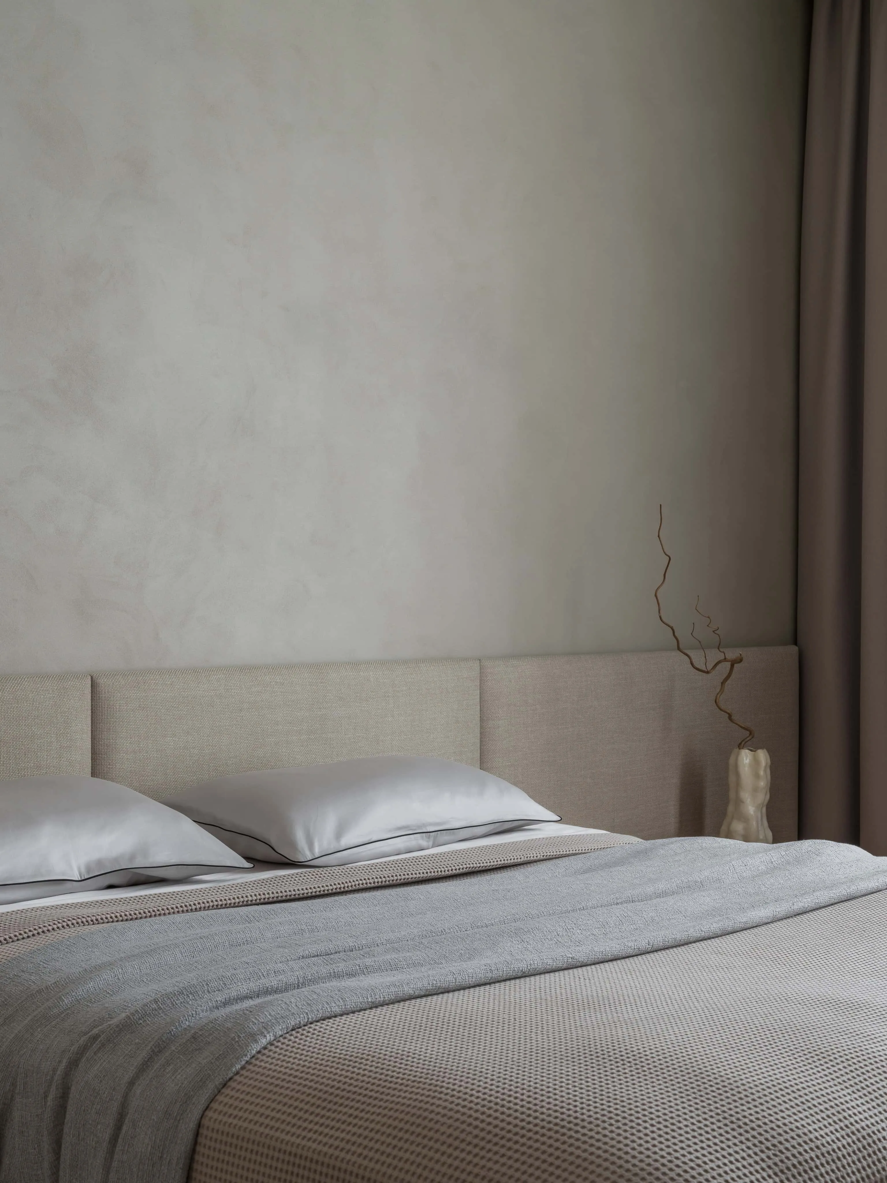 灰色与陶土色调柔软床品增强卧室宁静氛围。