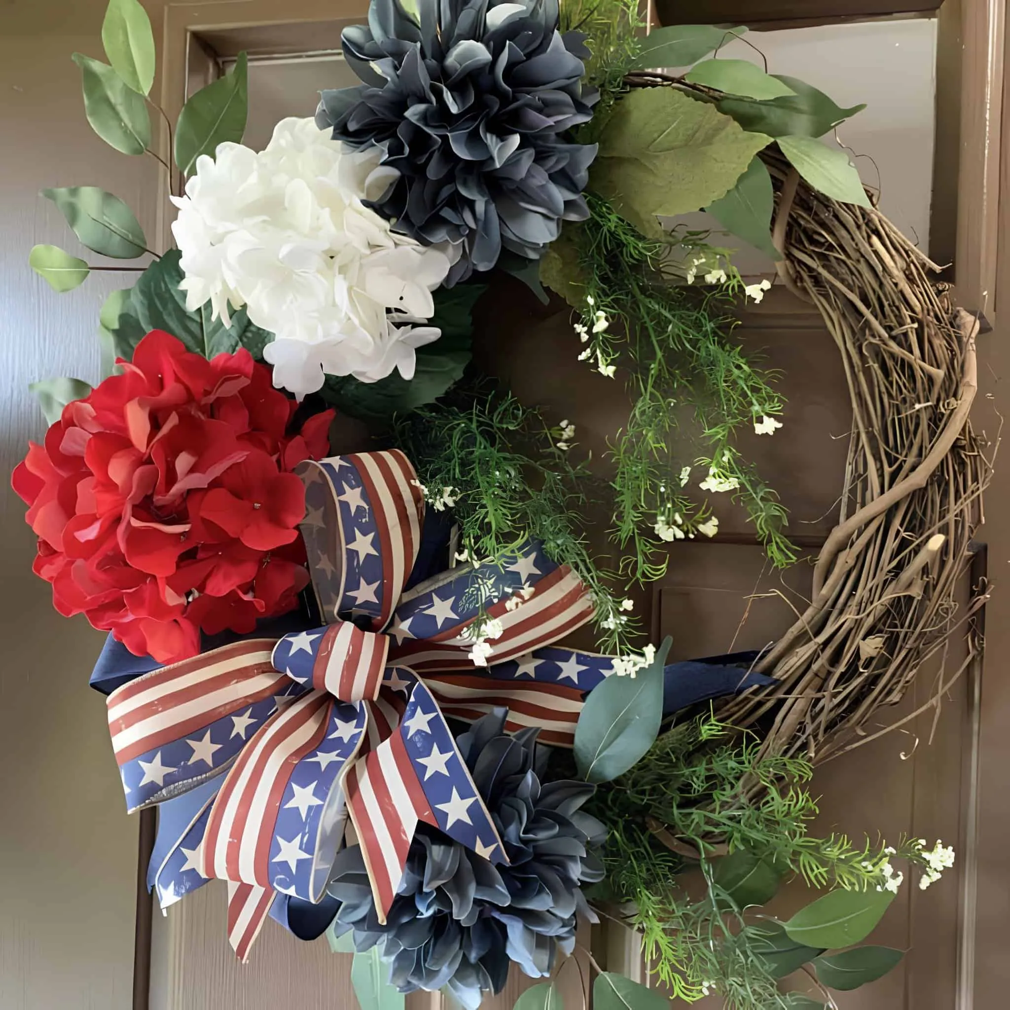 门前爱国花环，配有红、白、蓝花朵和条纹丝带