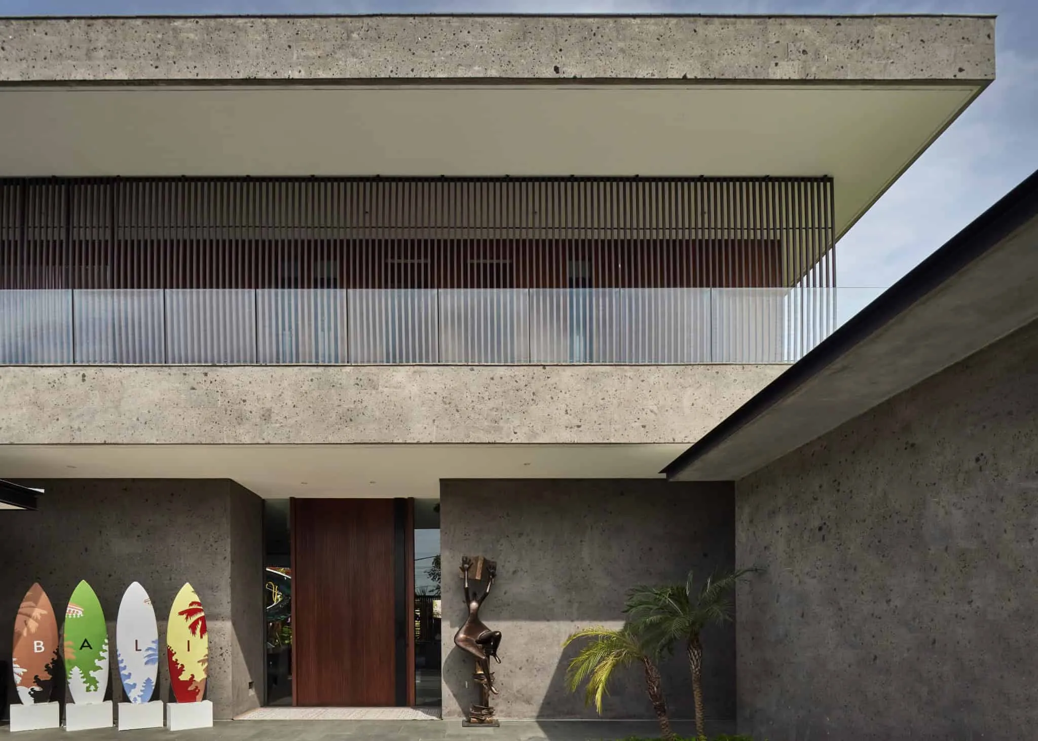 巴厘岛现代别墅立面，配有纹理混凝土和木质装饰。