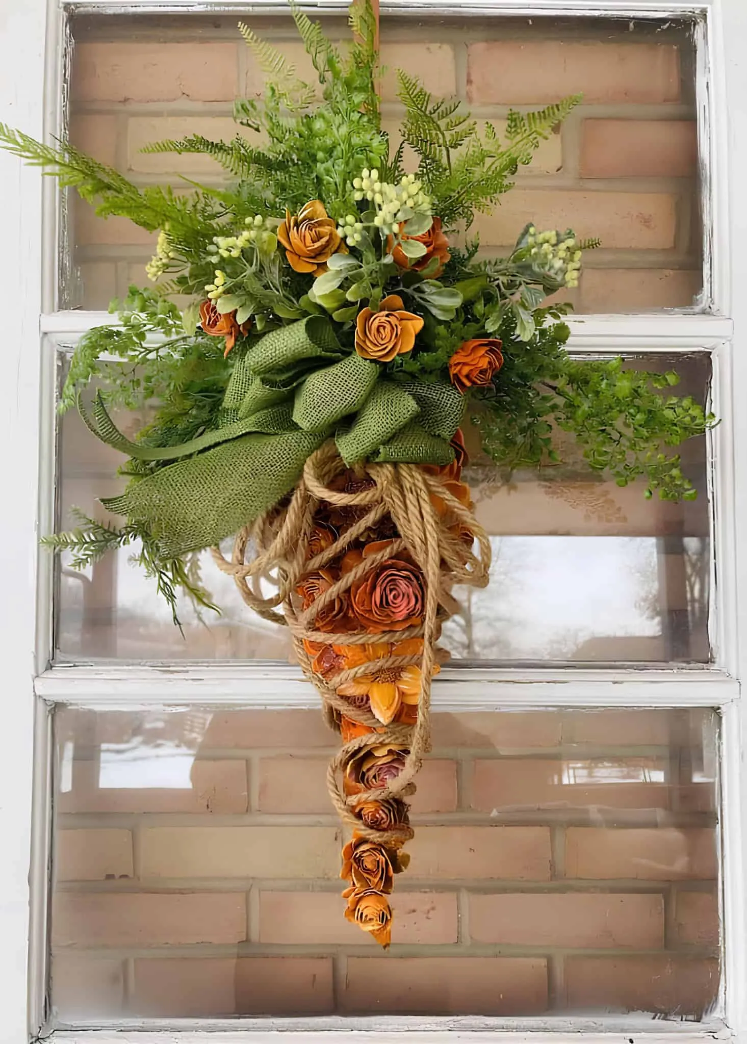 胡萝卜挂饰，配有橙色玫瑰、绿色粗麻丝带和丰富的绿叶