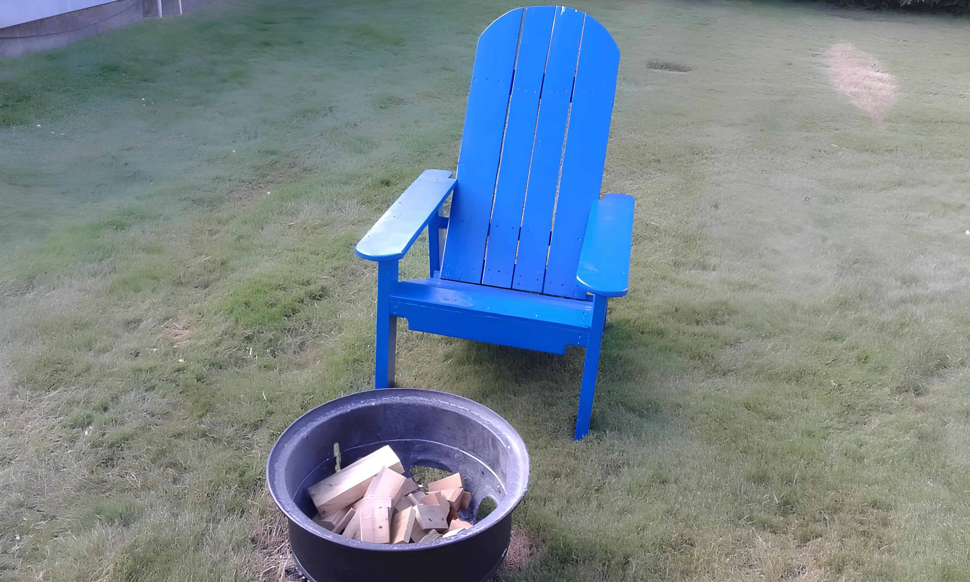 在篝火旁的明亮蓝色阿迪兰达克托盘椅