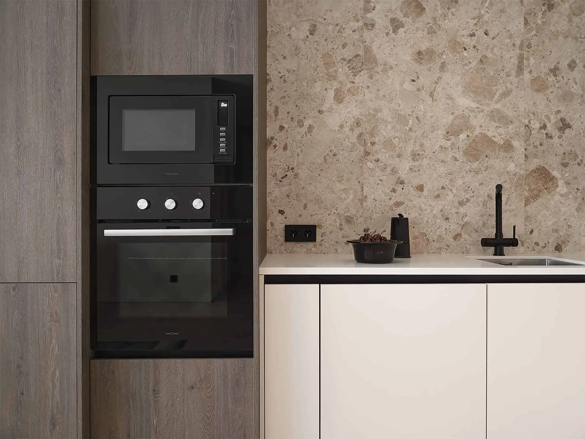 厨房全景图，配有黑色固定件和天然石材底板。