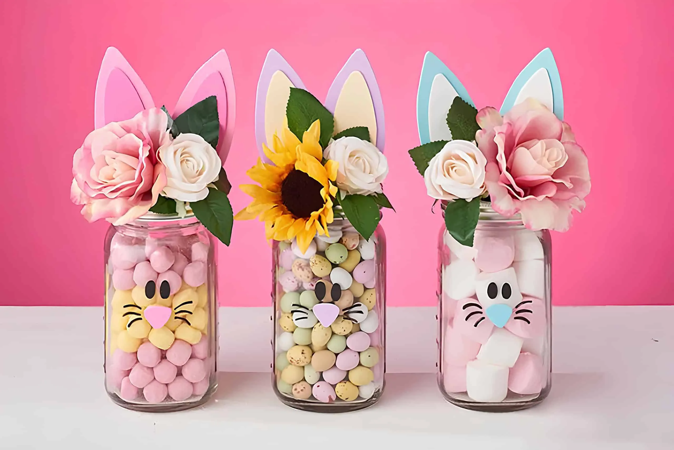三个复活节 Mason 罐子，装满糖果，装饰兔子脸、耳朵和花朵