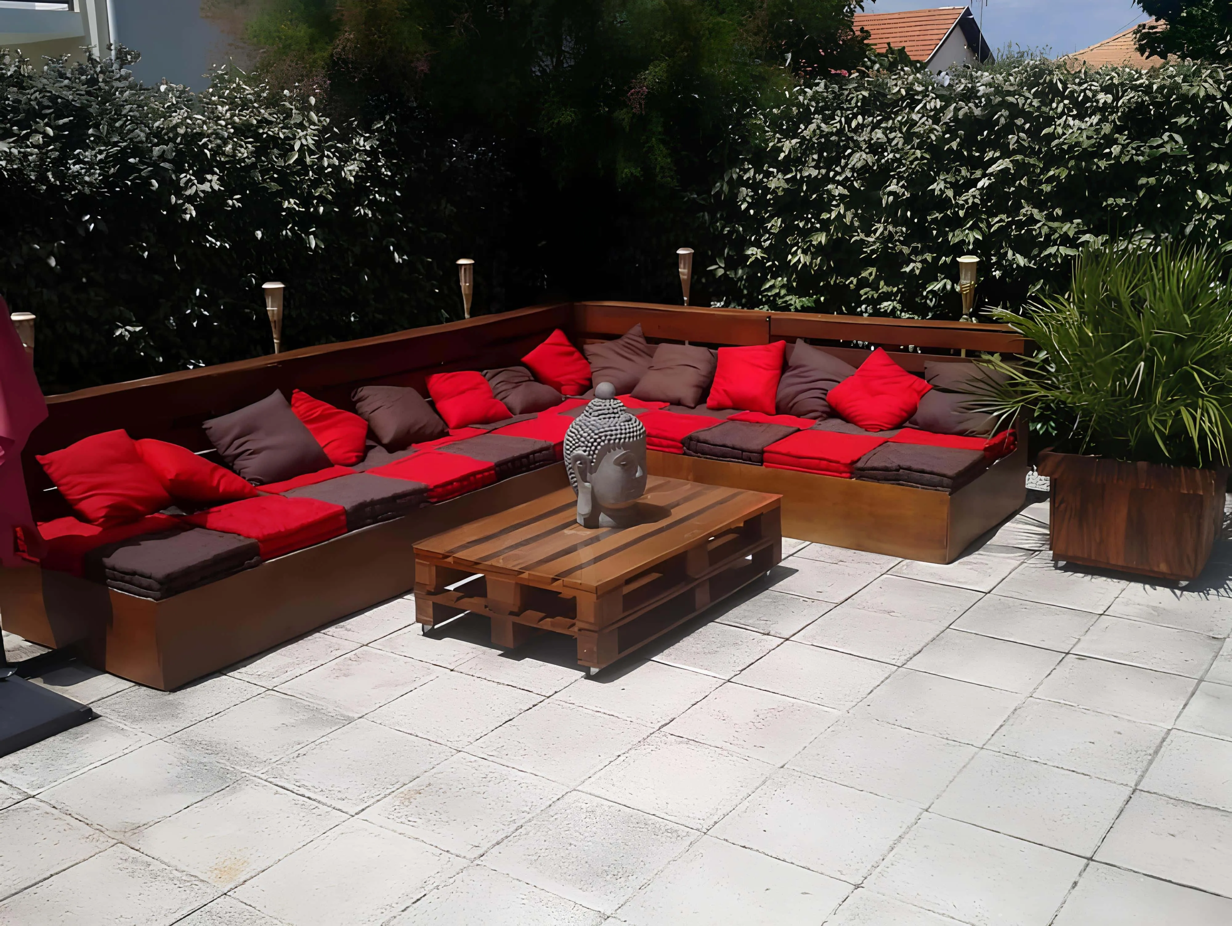 带红色和棕色靠垫的木制托盘沙发，围绕着中央佛像