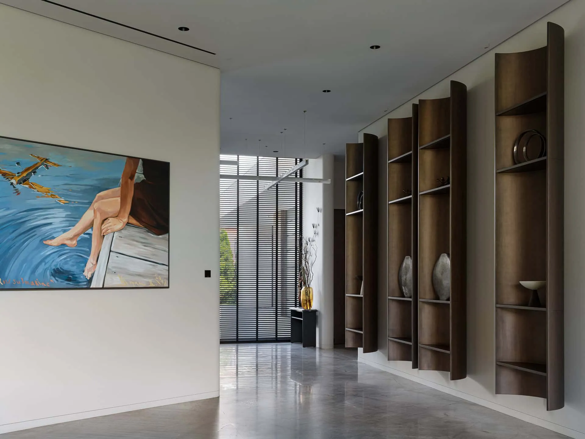 现代走廊中精心布置的墙面书架与彩色画作。