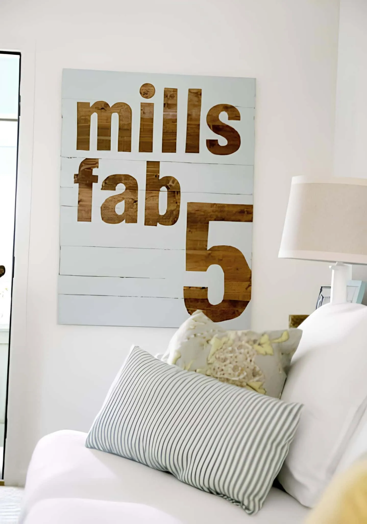 现代农舍风格的木质引用牌，上面有'mills fab 5'字样，放在白色沙发上
