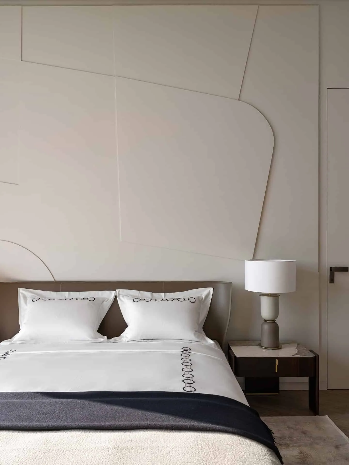 柔软床铺与纹理墙面的特写。