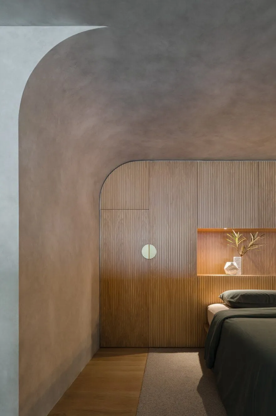 Brutalist bedroom with warm wooden finish and curved architectural ceiling