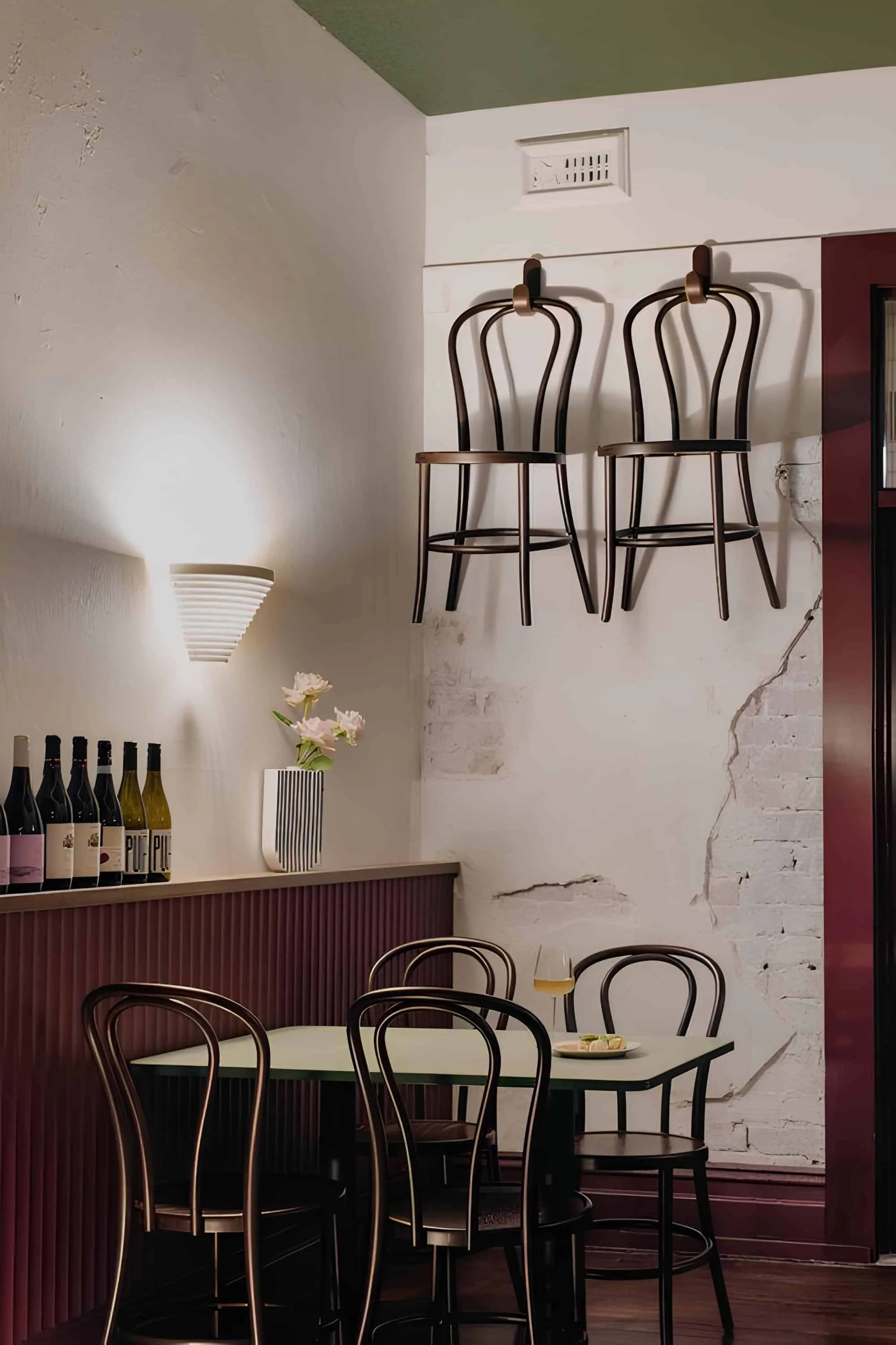 Hanging wooden chairs above vintage dining table at Vin Populi Next Door