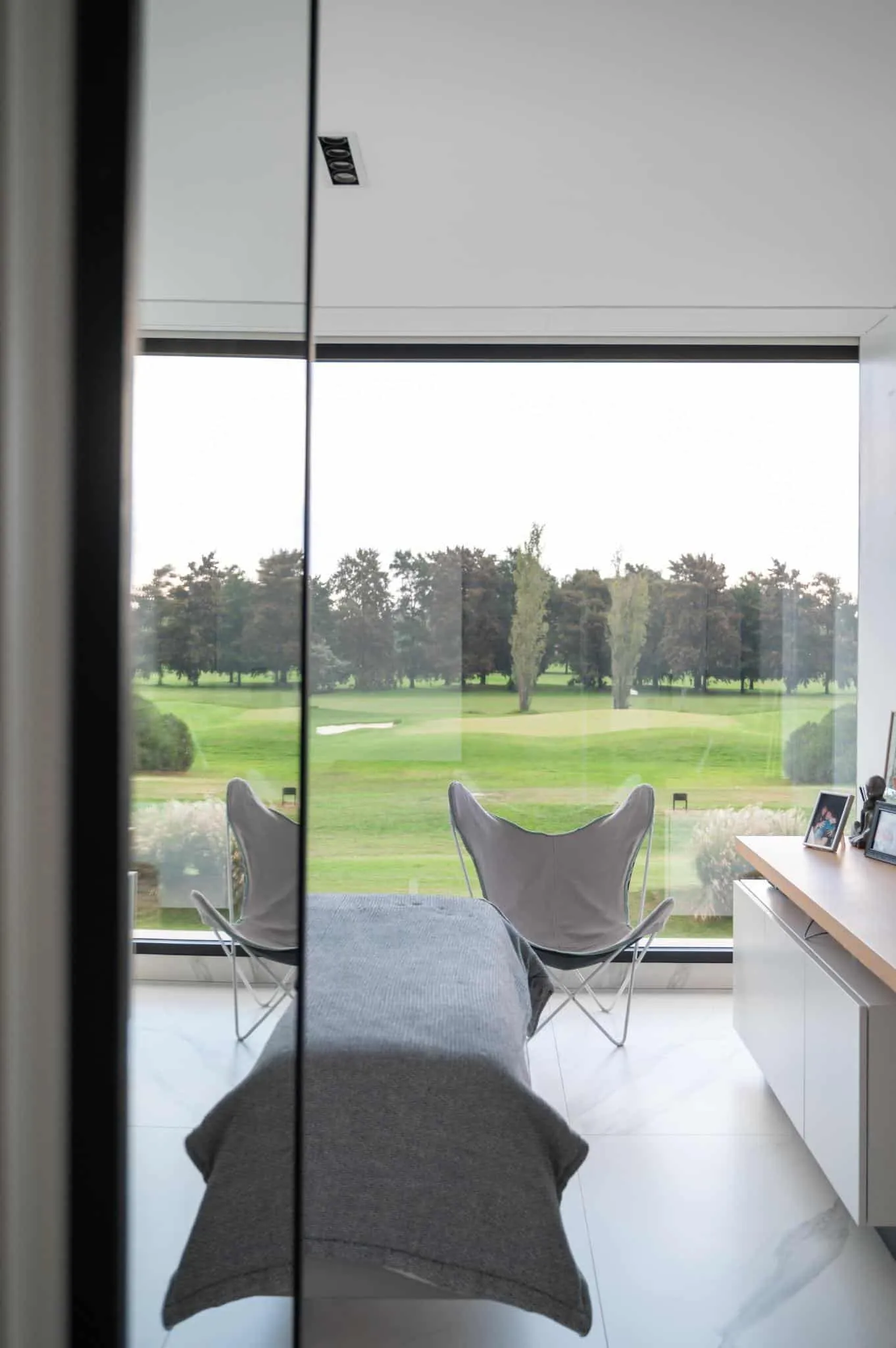 帕切科住宅卧室，透过大全景窗俯瞰绿色高尔夫球场