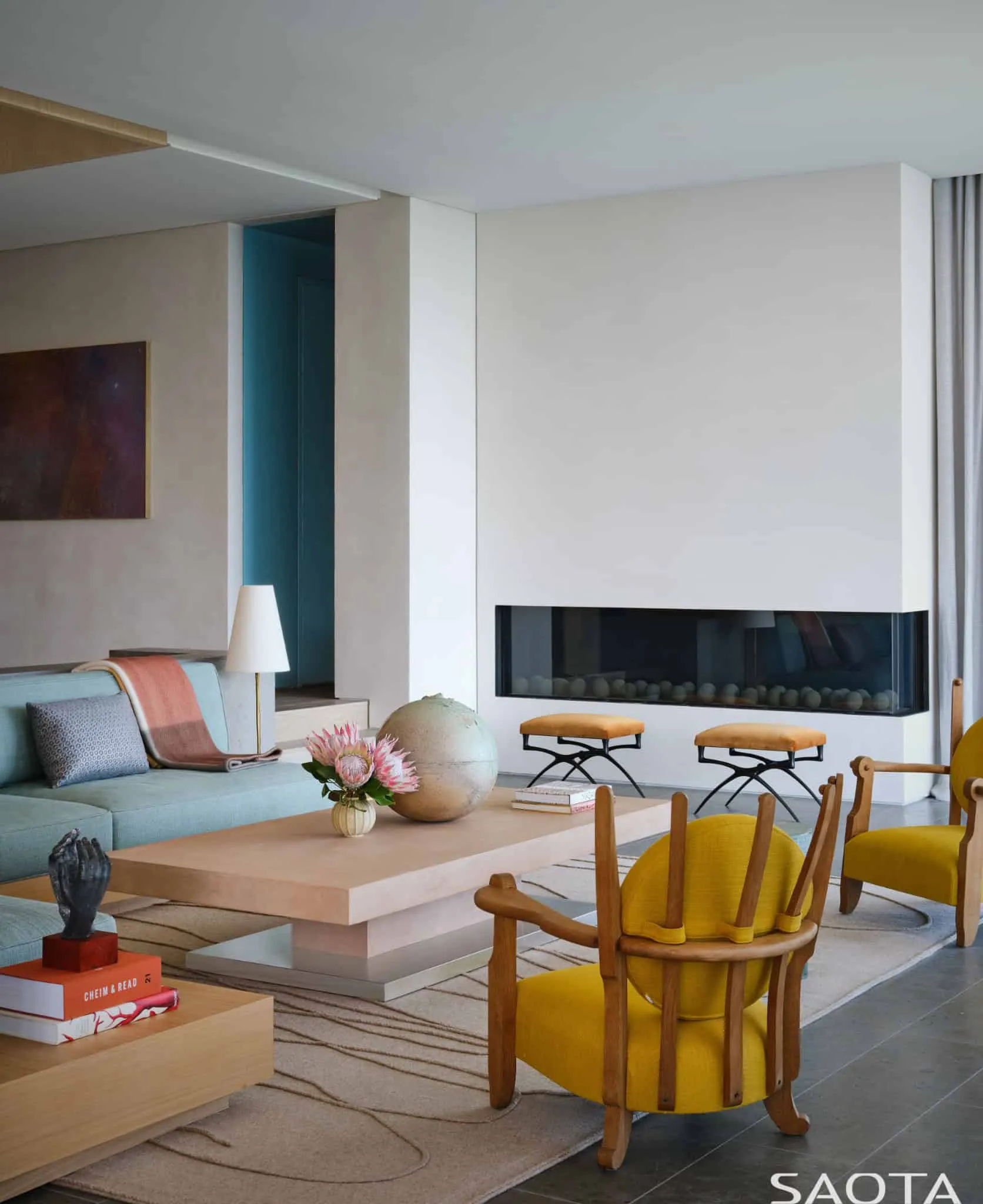 蒙托克住宅的彩色客厅，配有黄色扶手椅和现代软装。