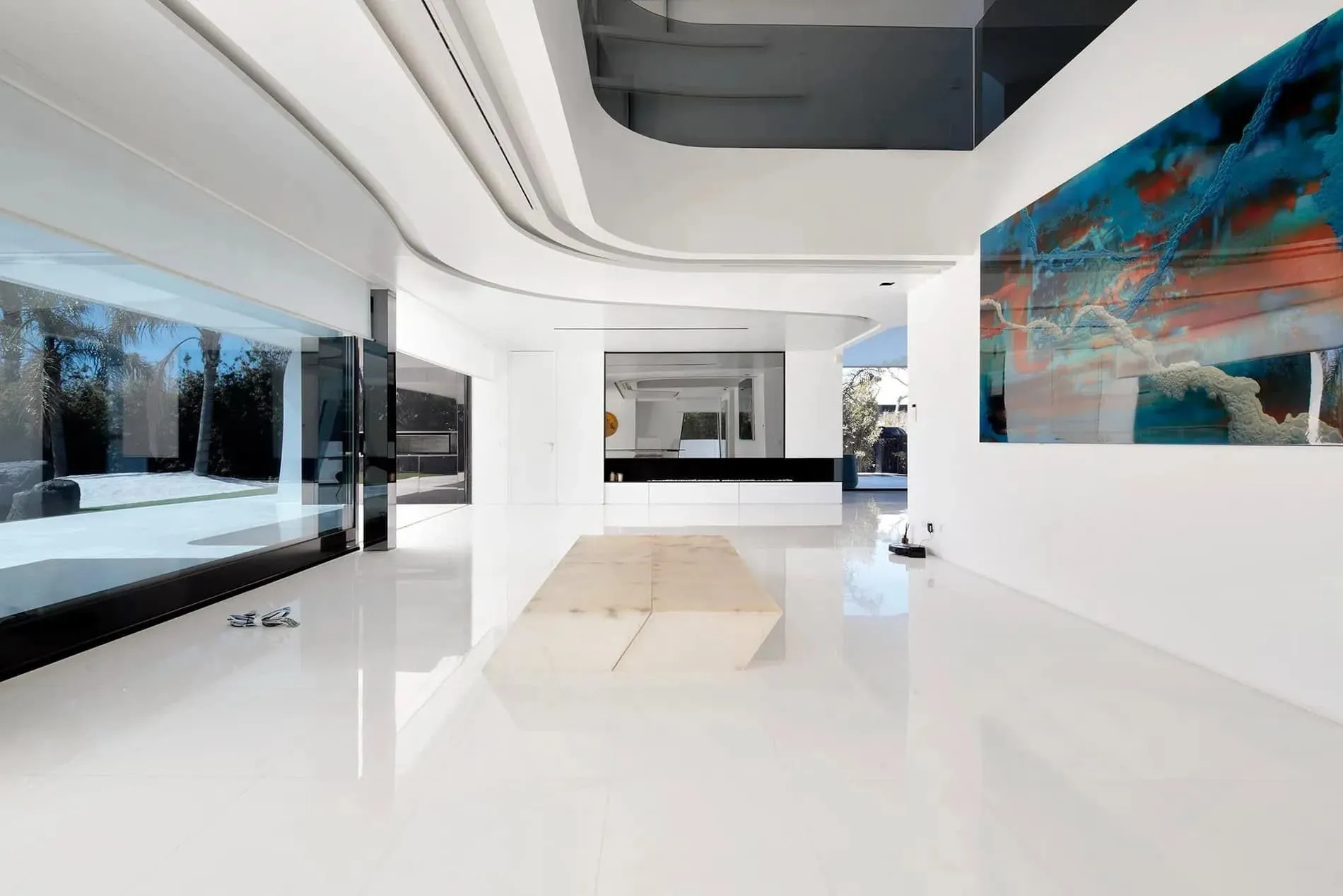 白色抛光表面的雕塑式厨房岛台，配有极简现代风格