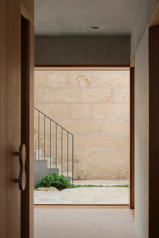 Minimalist stairs on textured limestone wall in Newcastle home
