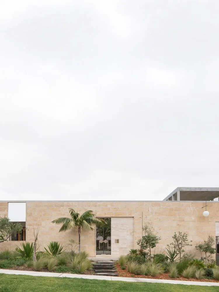Main limestone entrance wall with palm landscape and walkway in Newcastle