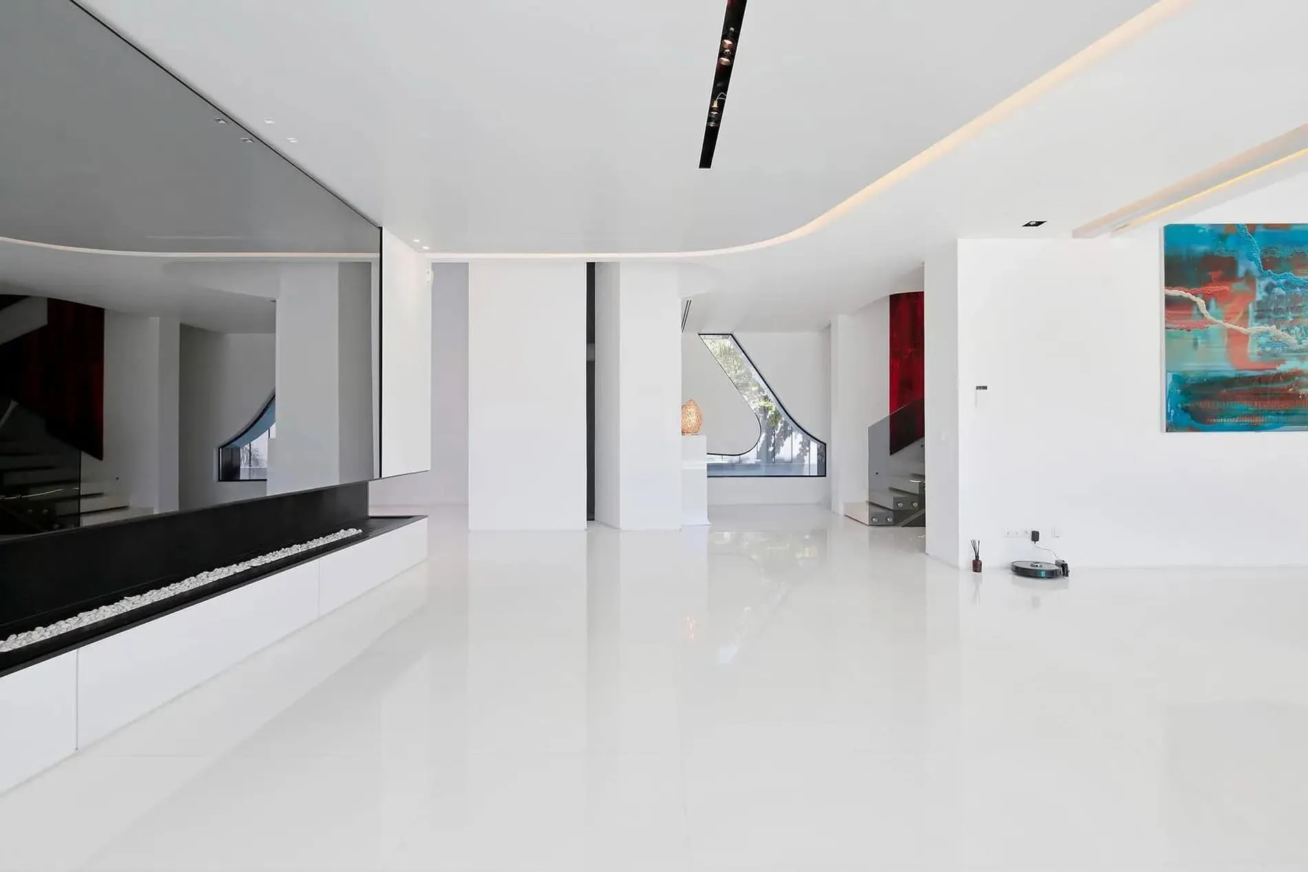 全白的开放客厅区域，配有极简设计，展示瓜马尔别墅