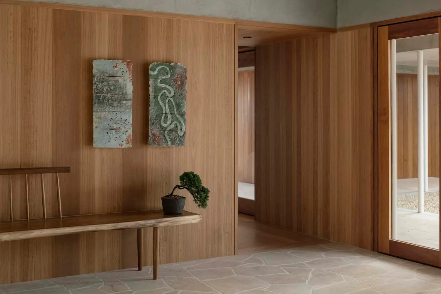 Minimalist wooden interior with stool, bonsai and abstract wall art in Newcastle