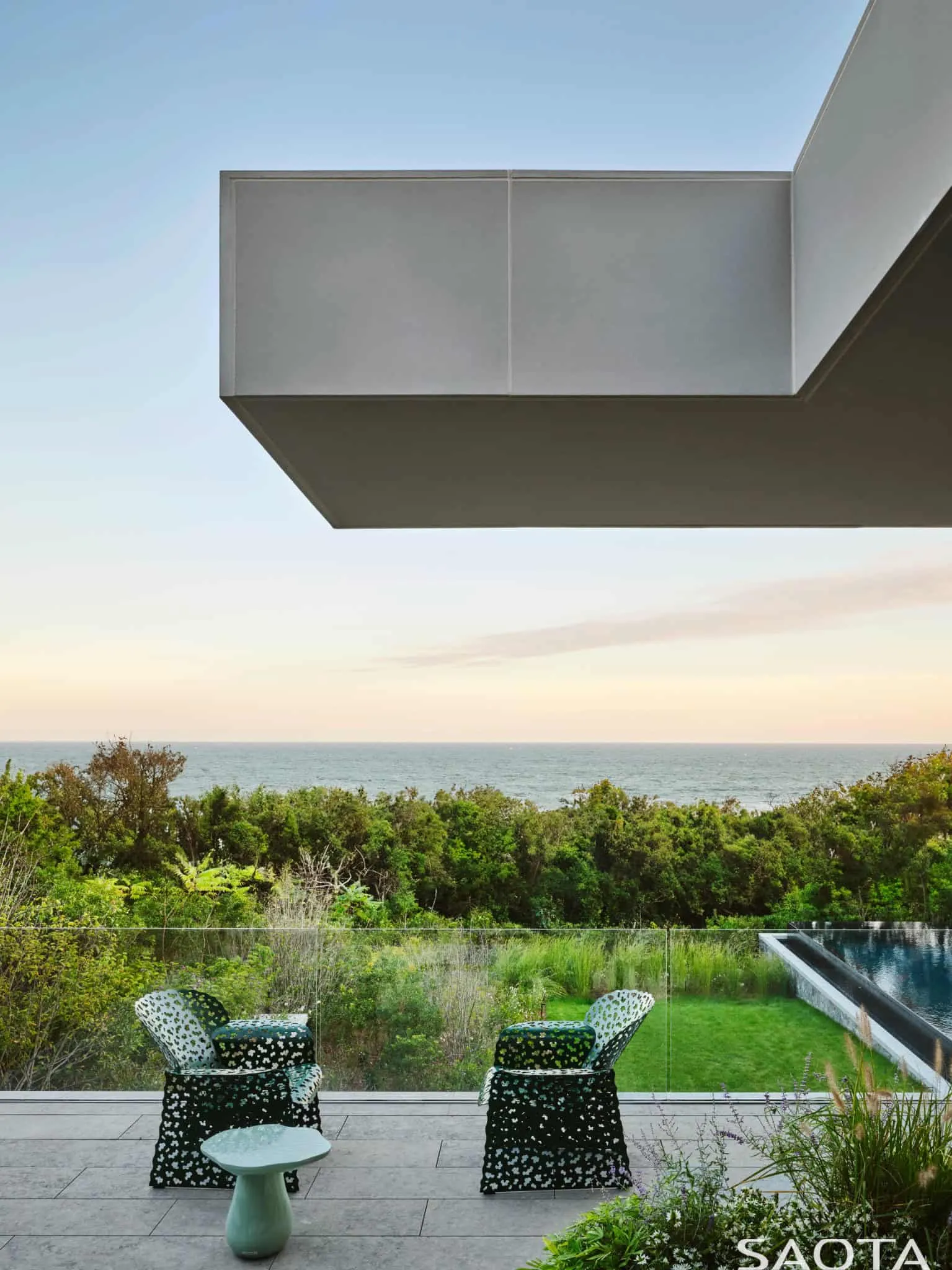 蒙托克住宅玻璃阳台上的大西洋日落景色。