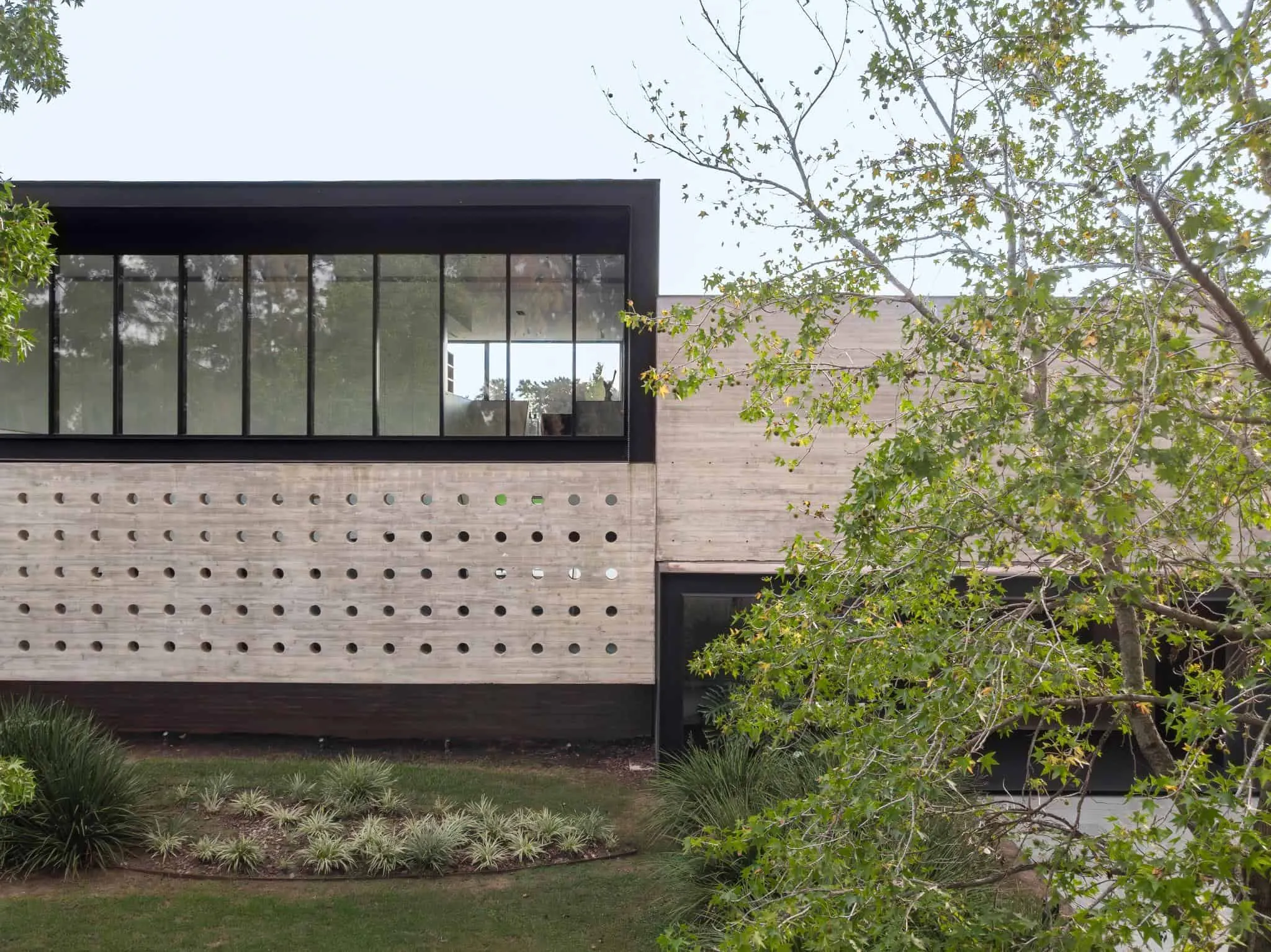 帕切科住宅穿孔混凝土立面，带有均匀分布的圆形开口