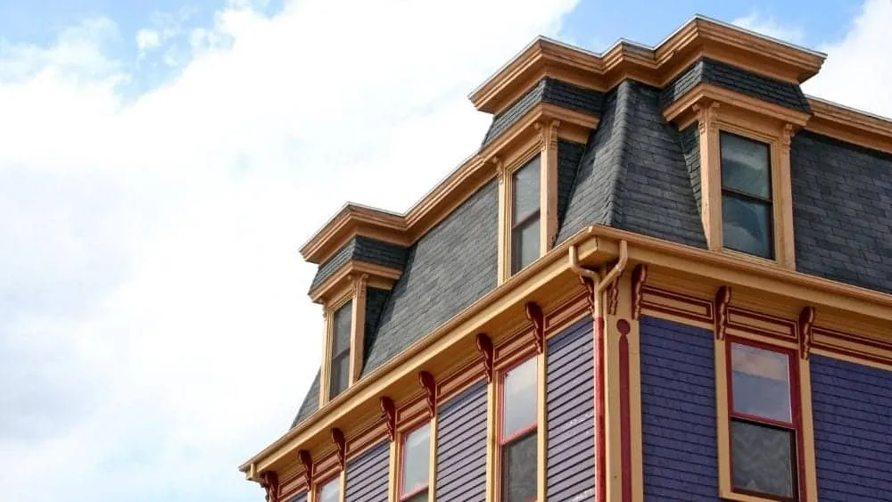 Colorful Victorian house with a mansard roof and decorative eaves