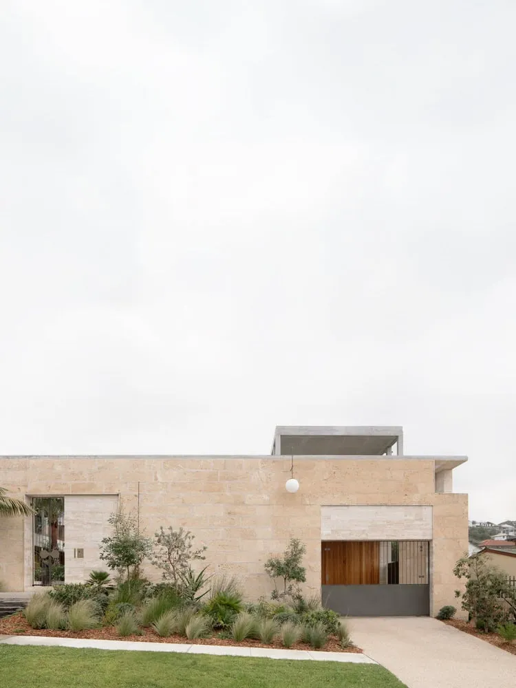 View of main gates and driveway framed by natural stone in Newcastle