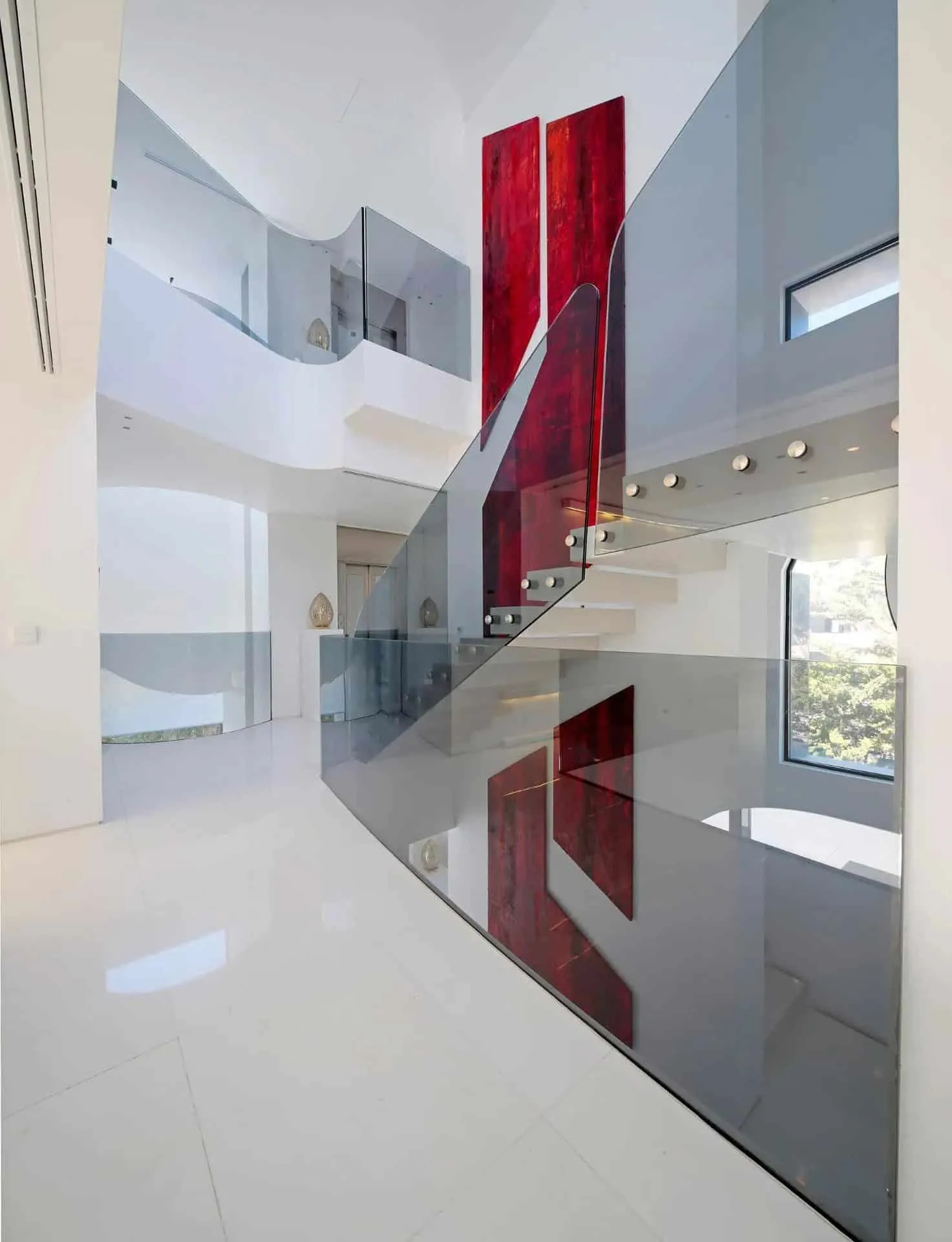 现代明亮走廊，配有泳池景观、漂浮台阶和弯曲天花板