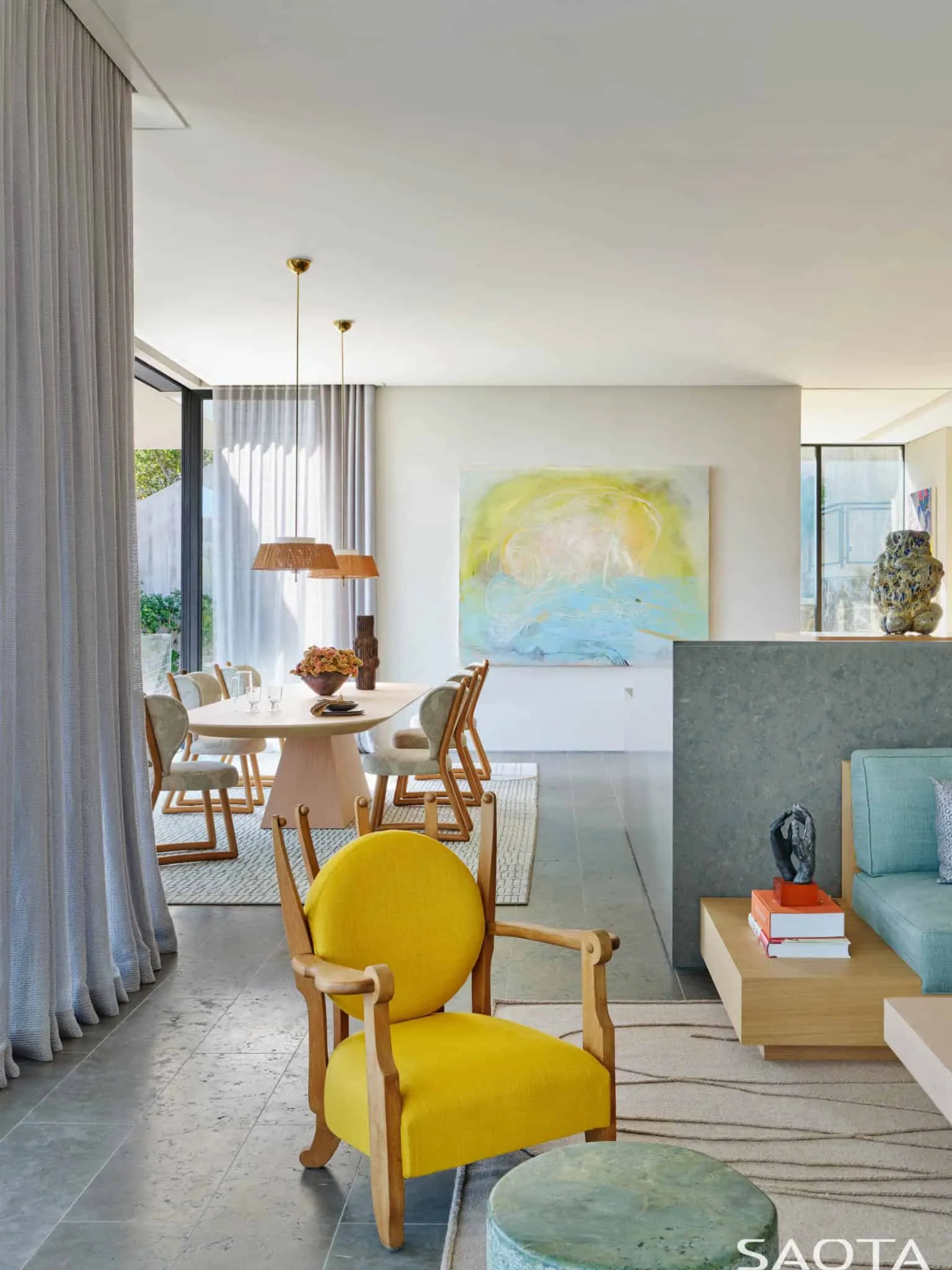 蒙托克住宅的开放式餐厅和客厅，配有大型艺术品和玻璃墙。