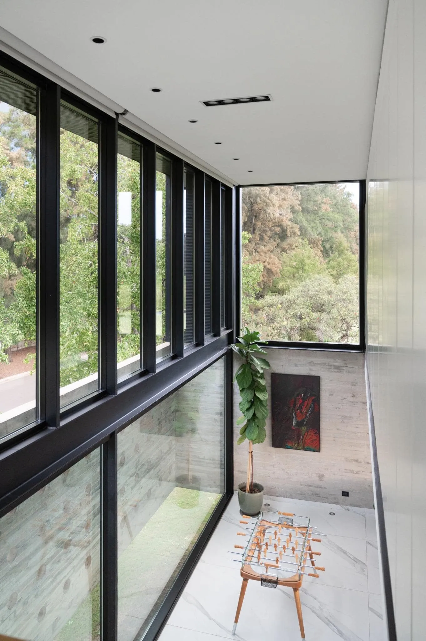 帕切科住宅游戏区，配有餐桌和全尺寸角窗俯瞰绿色景观