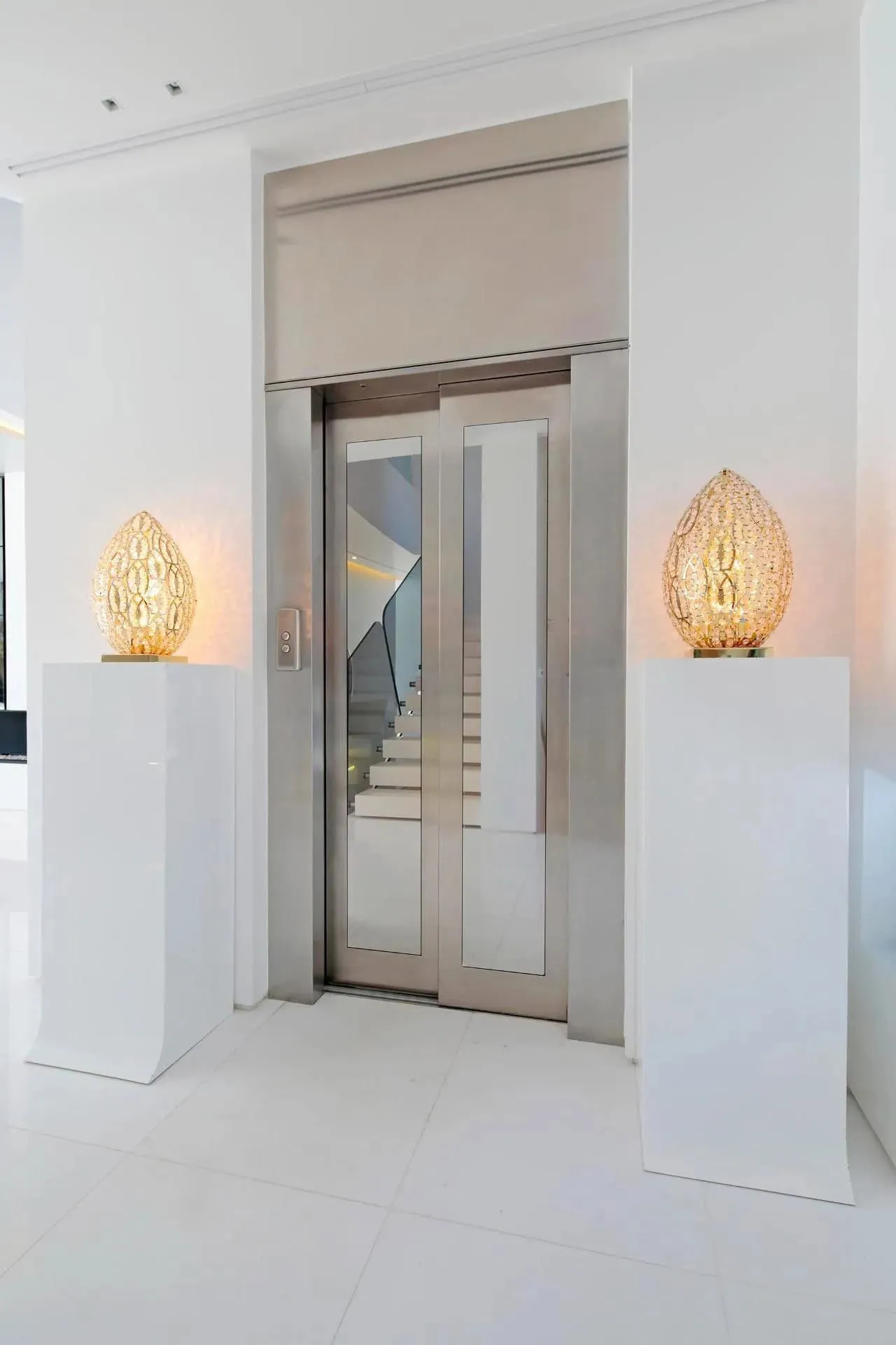 现代白色内饰，配有内置书架和面向海洋的大窗户