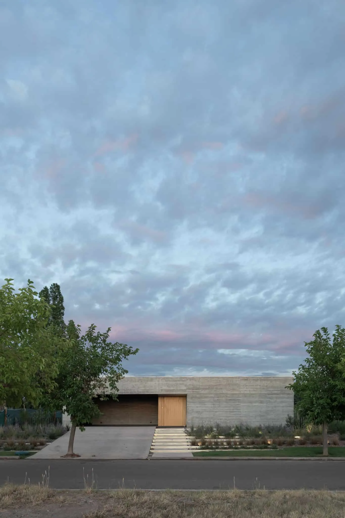 A4estudio设计的Casa Anabela街道视图，树木环绕。