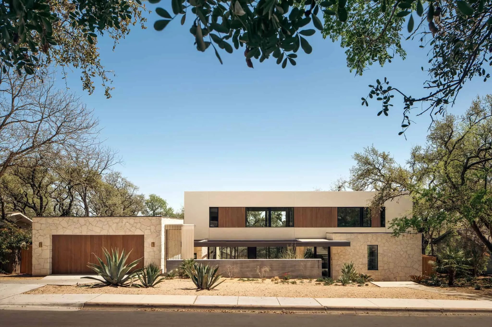 Фасад Casa Solis, обращенный к улице с чистыми линиями и естественными текстурами.