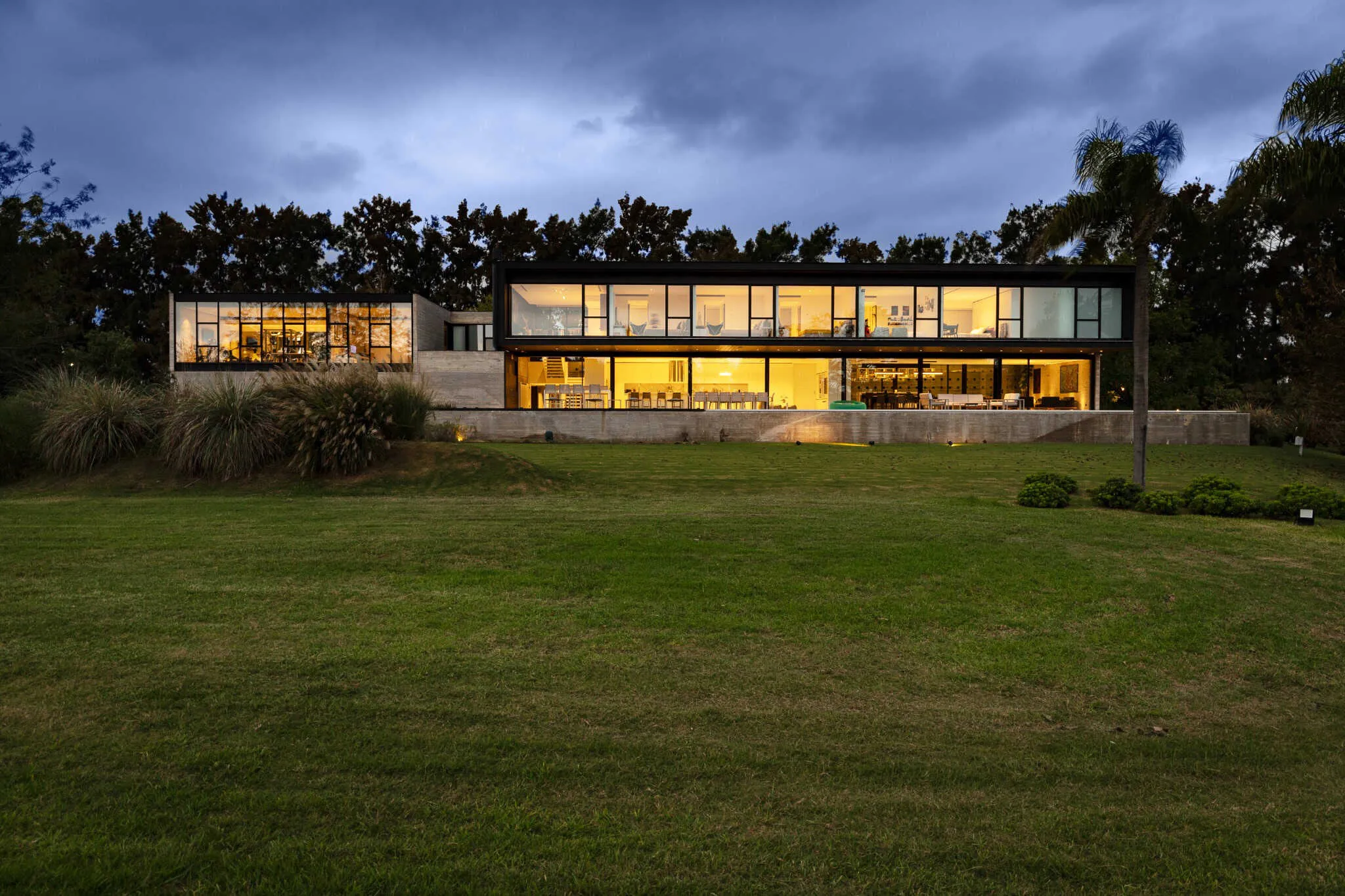 夜间帕切科住宅，玻璃立面被灯光照亮