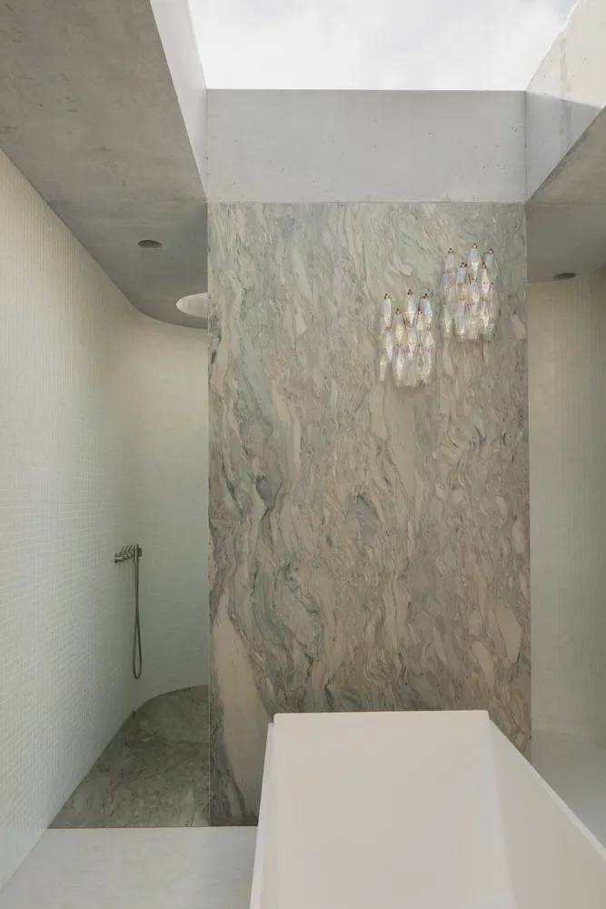 Sculptural marble bathroom wall with tub and skylight in Newcastle