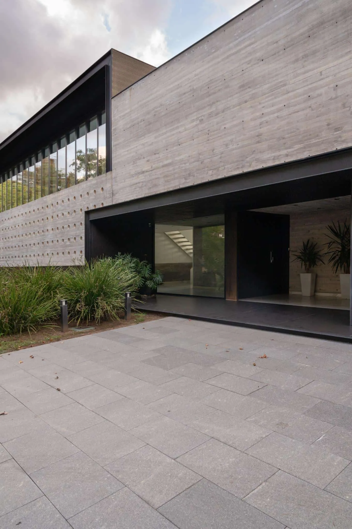 帕切科住宅主入口特写，带有深色金属框架和绿色植被