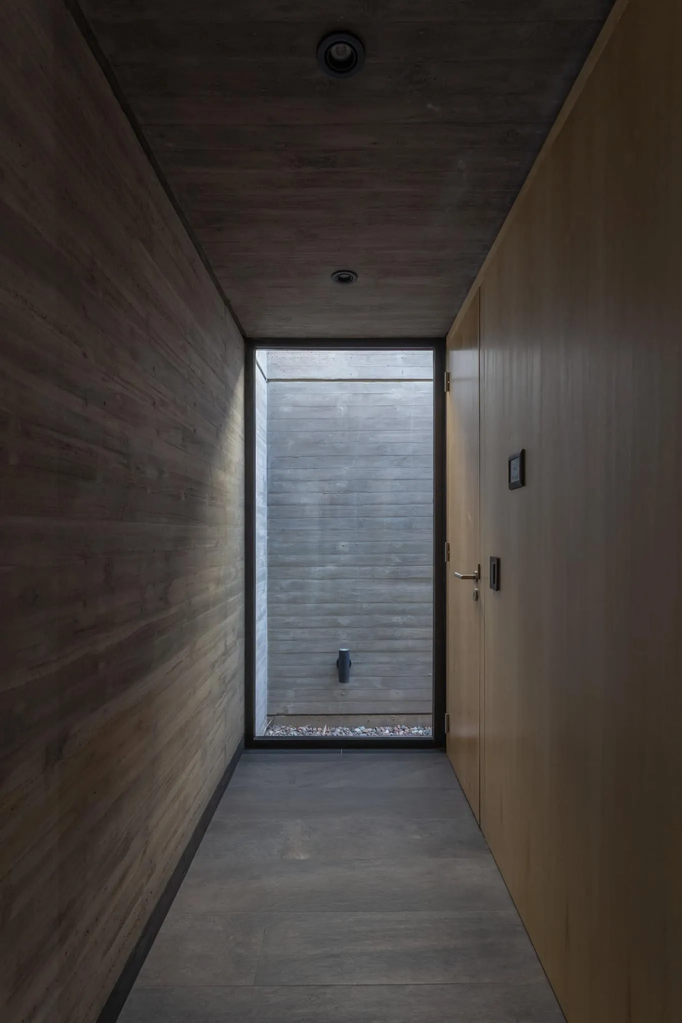 A4estudio设计的Casa Anabela以玻璃结束的走廊。