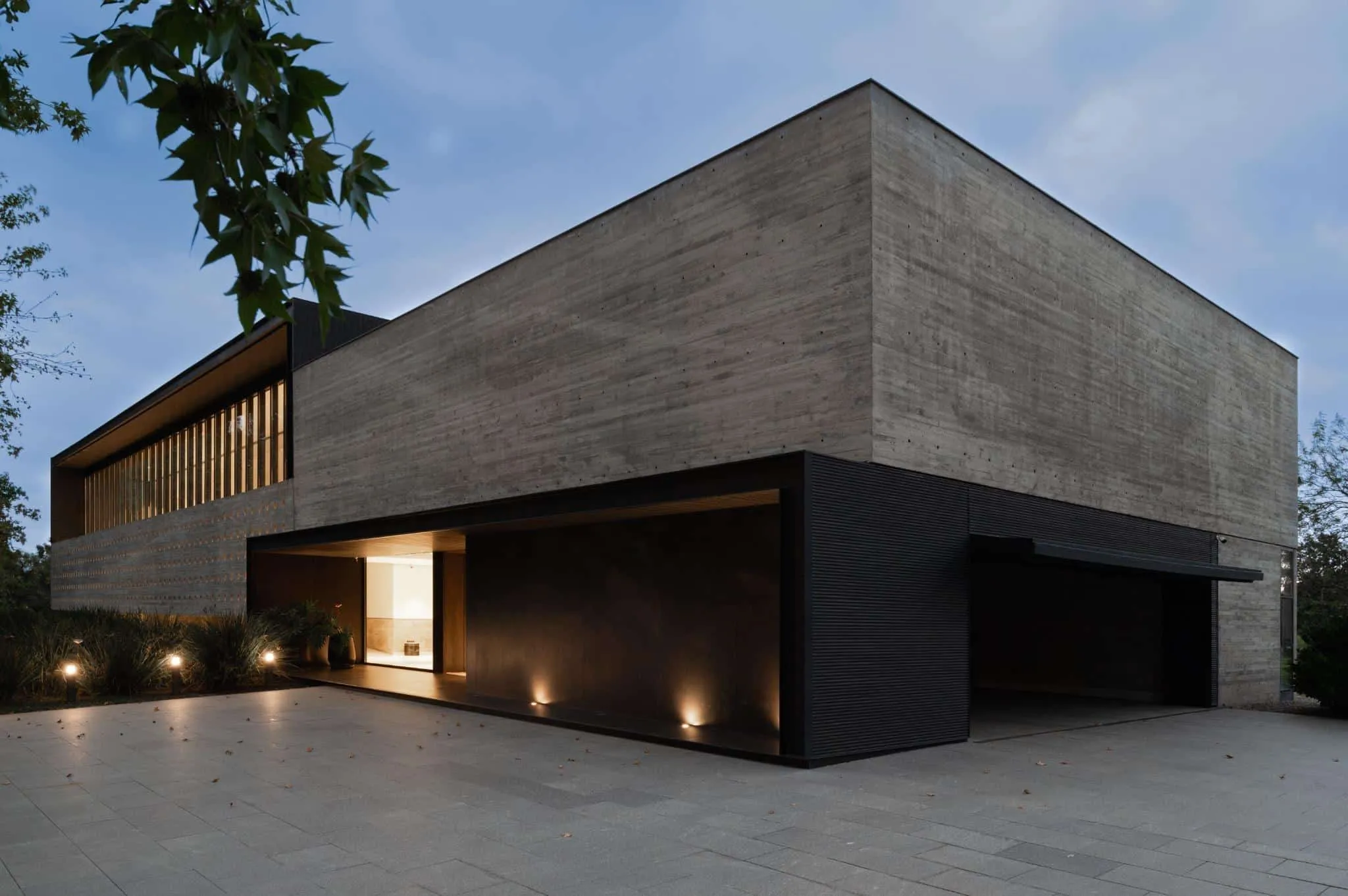 帕切科住宅夜间外观，极简照明与坚定混凝土几何