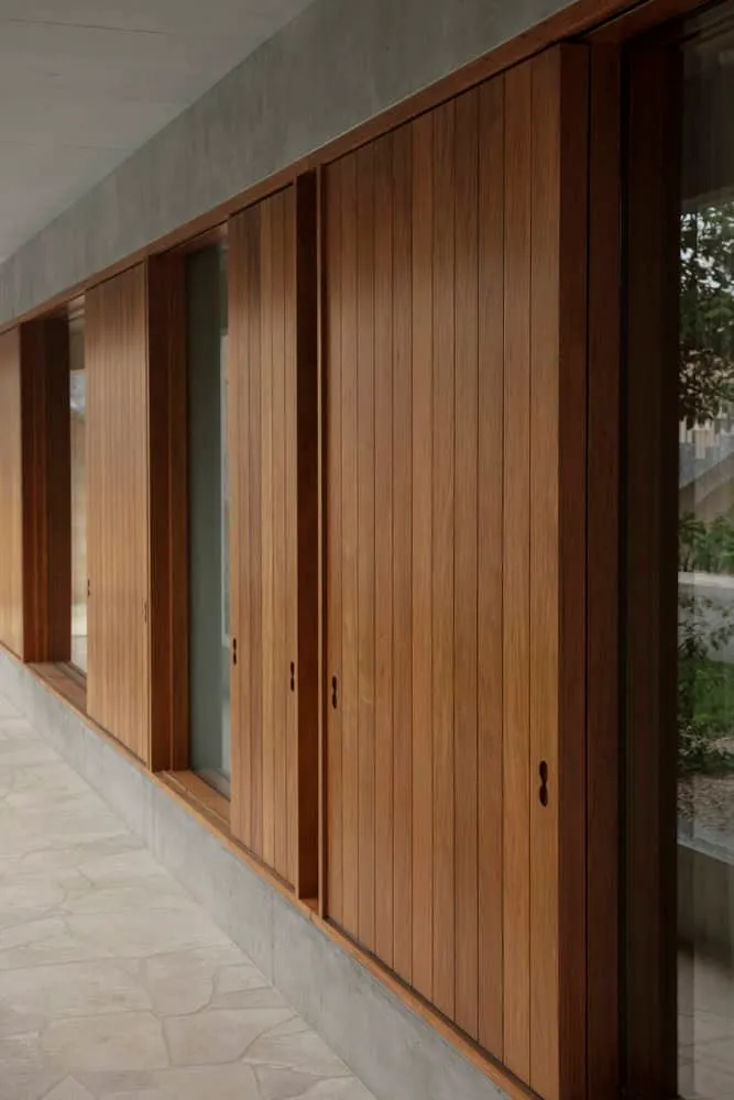Close-up of vertical wooden louvers and concrete base wall in Newcastle