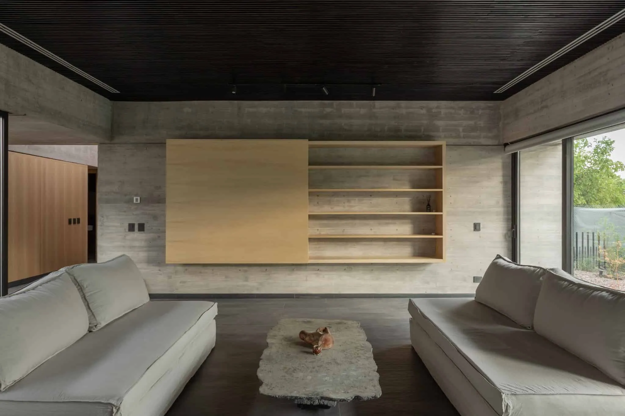 A4estudio设计的Casa Anabela温馨客厅与木质书架。