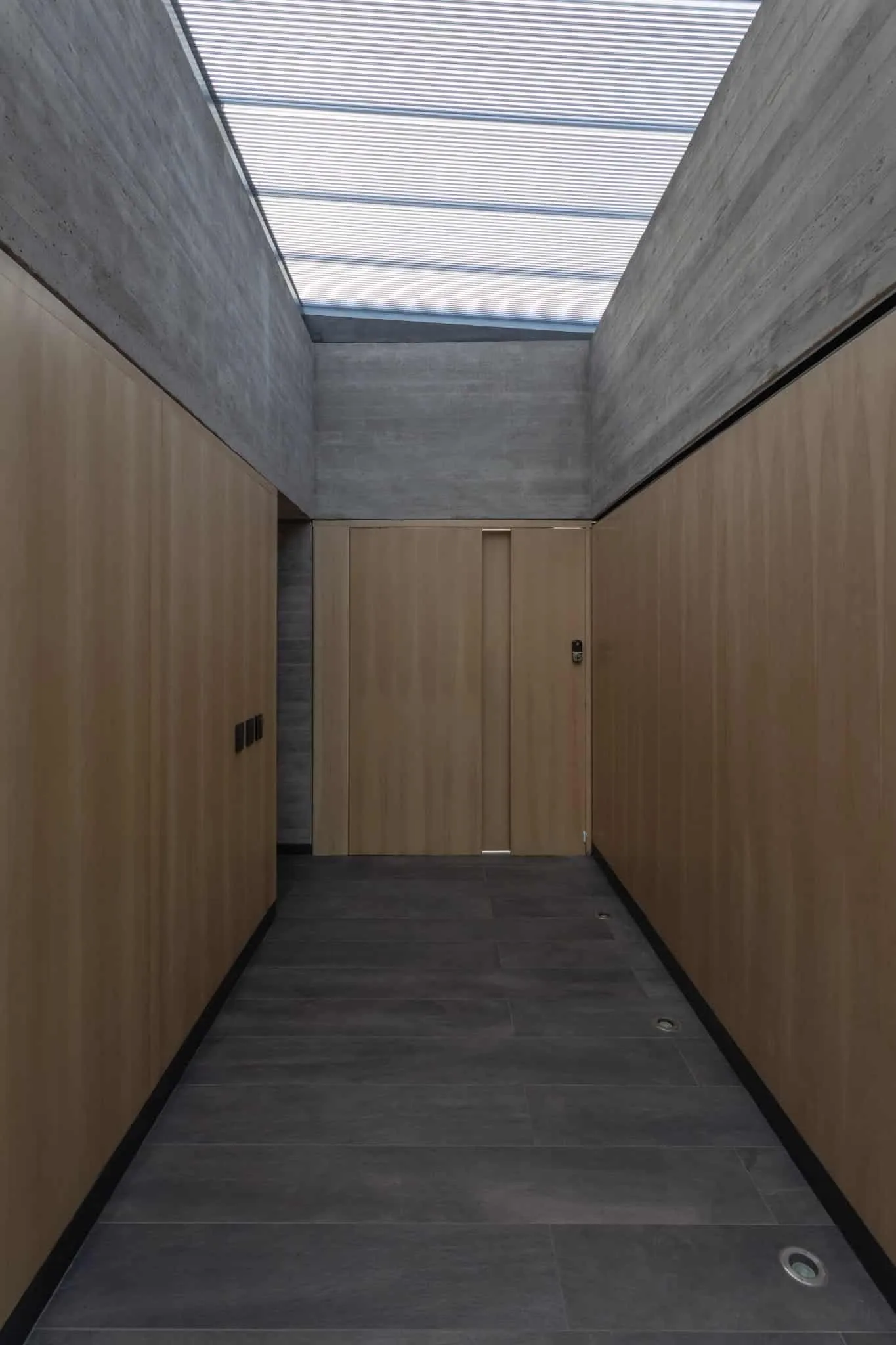 A4estudio设计的Casa Anabela内部木质走廊通往房间。